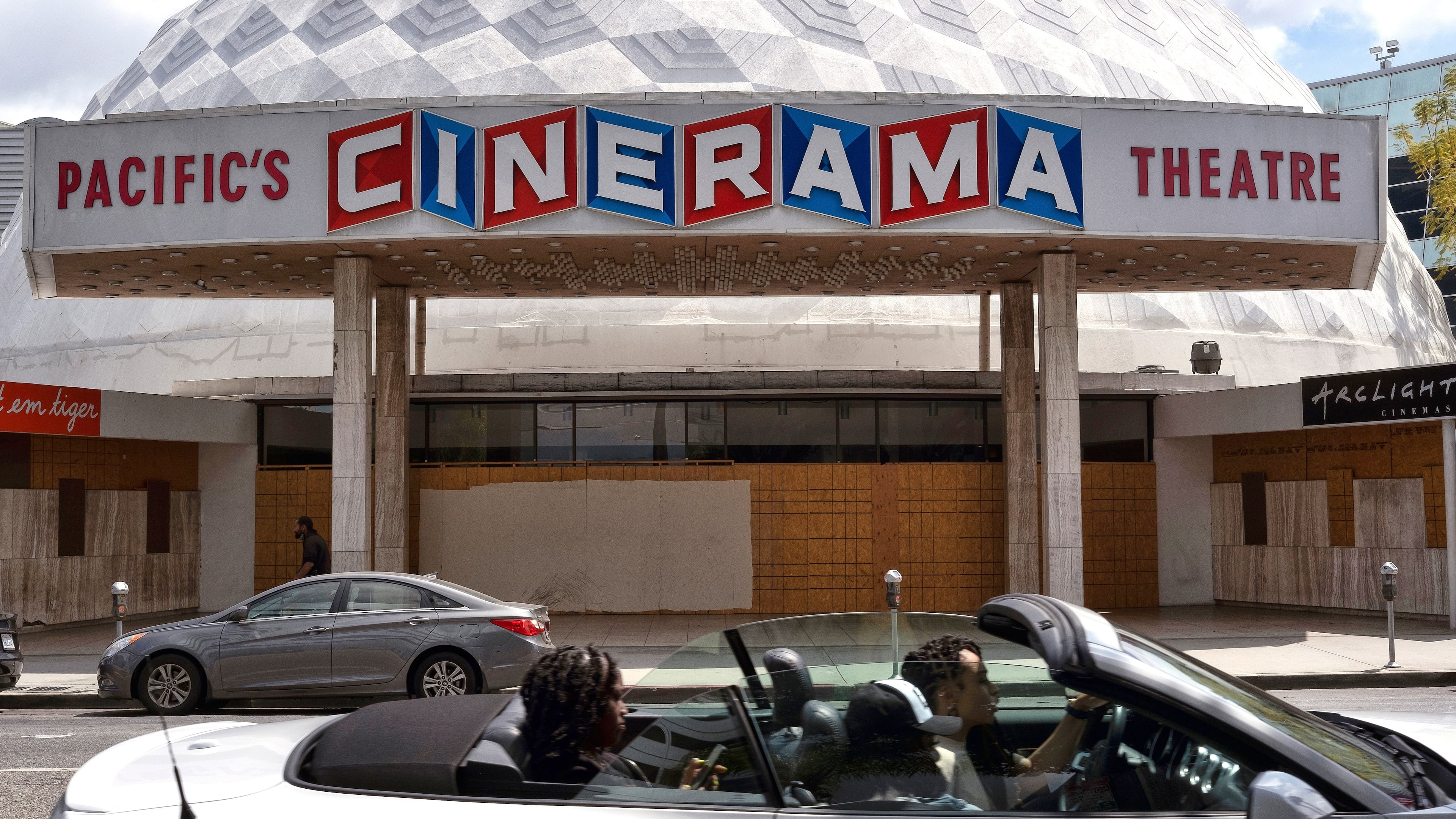 FILE - A motorist drives past the Cinerama Dome movie theater in Los Angeles on April 25, 2021. (AP Photo/Richard Vogel, File)