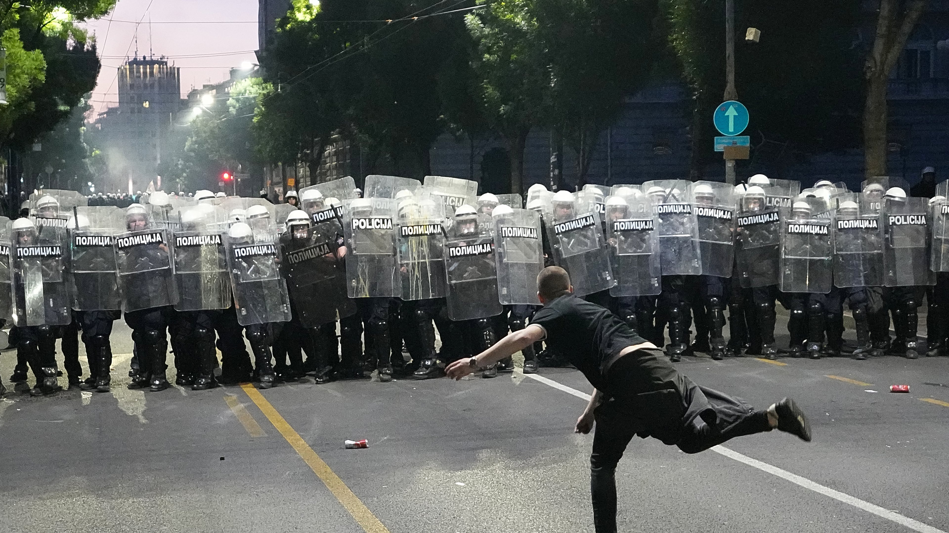 A man throws a cobblestone at riot police as clashes break out during a rally led by Serbia's protesting university students who are pushing for major political changes in the Balkan country run by President Aleksandar Vucic, in Belgrade, Serbia, Saturday, May. 23, 2026. (AP Photo/Darko Vojinovic)