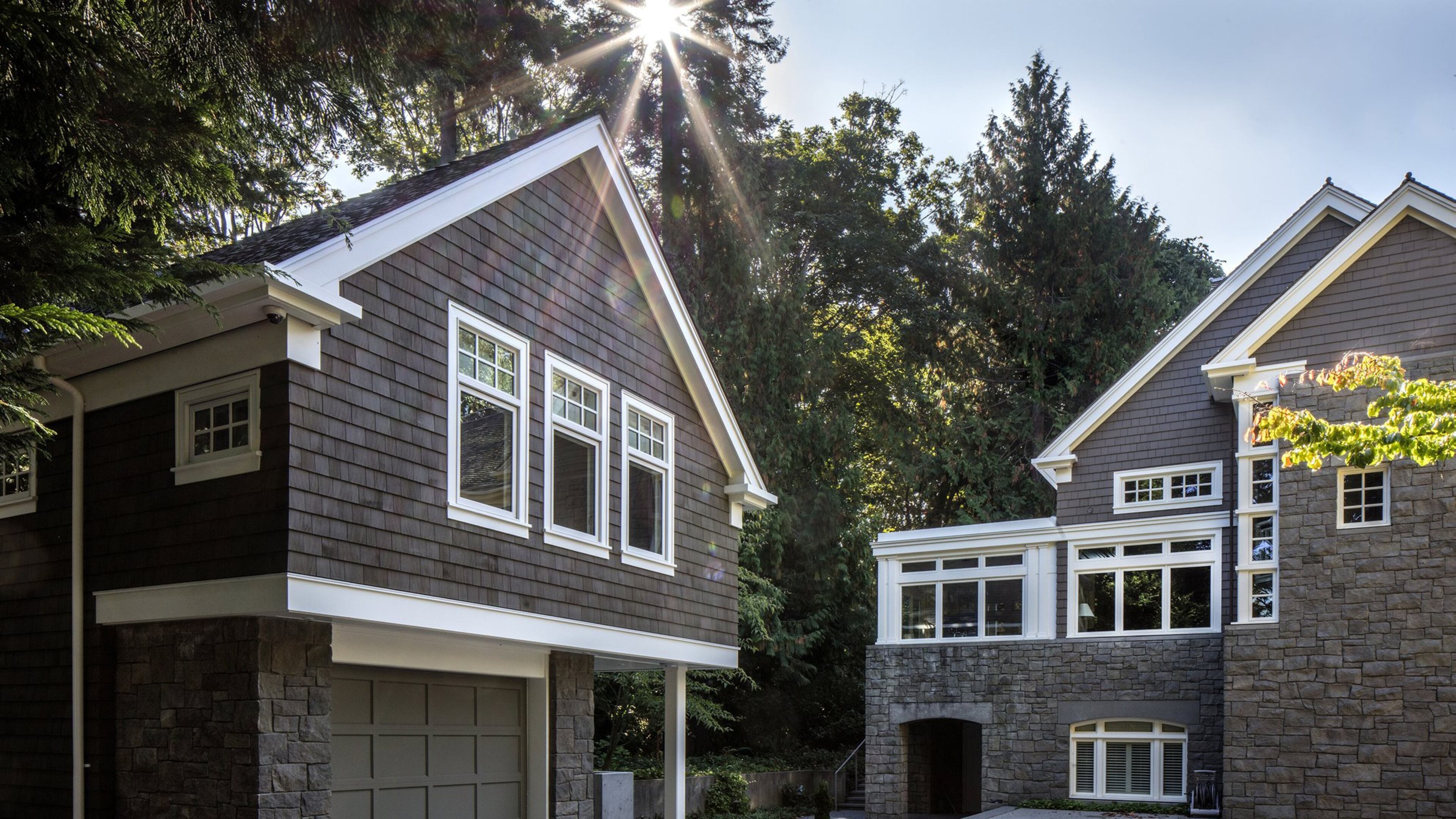 The bluestone patio was existing, says architect Tyler Engle, but everything to the west of it pervious concrete and pavers is new. While Kevin and Carolyn s guesthouse, left, mimics the main home, We used three windows in the front, instead of a pair. (Steve Ringman/Seattle Times/MBR)