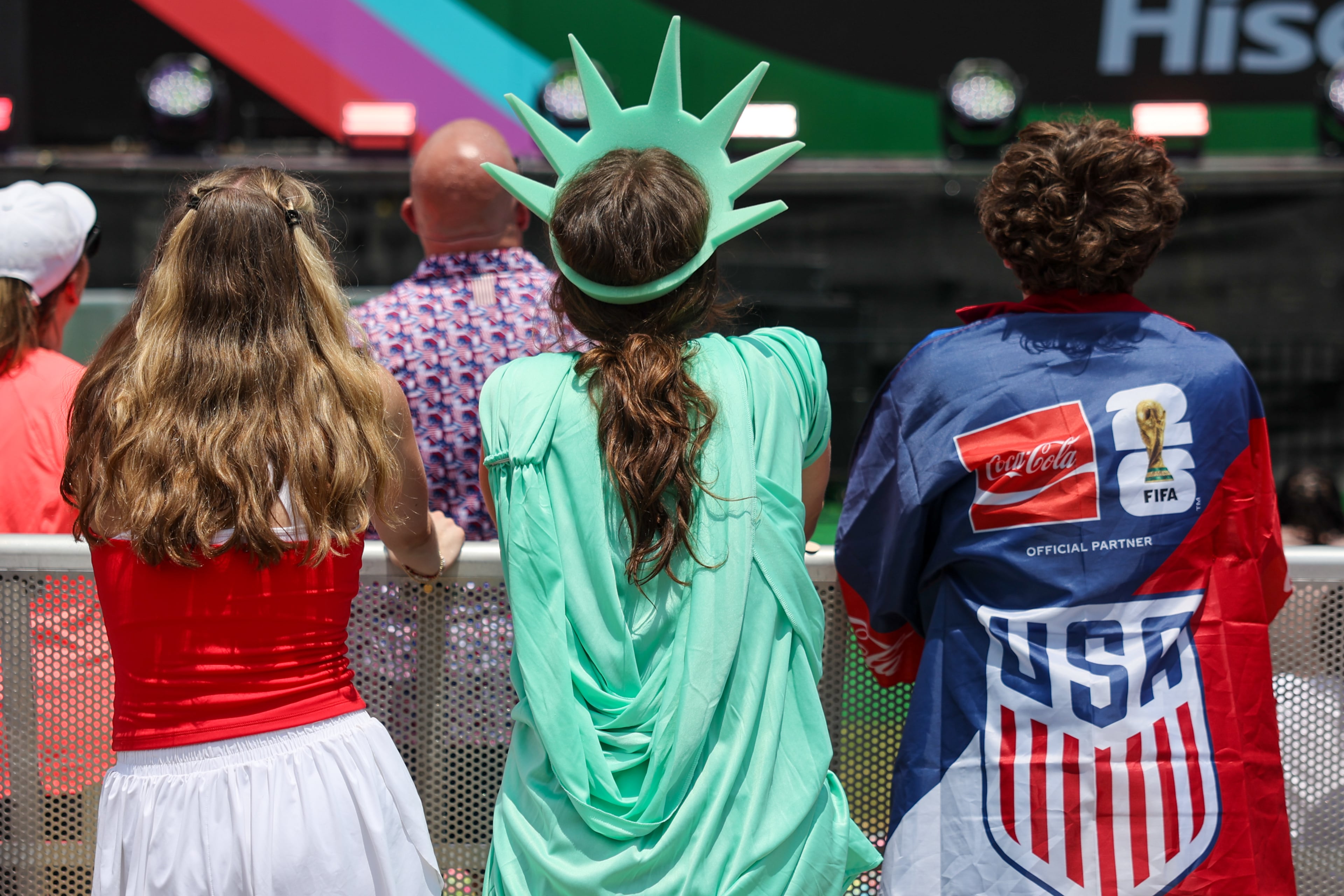 Mallory Hatmaker (center), dressed as the Statue of Liberty, watches the screen at Fan Fest in Centennial Olympic Park in Atlanta in the second half of the England versus Congo FIFA World Cup game on July 1, 2026. The game was played in Atlanta Stadium (Mercedes Benz Stadium) for the knockout round of 32. England won 2-1. (Arvin Temkar/AJC)