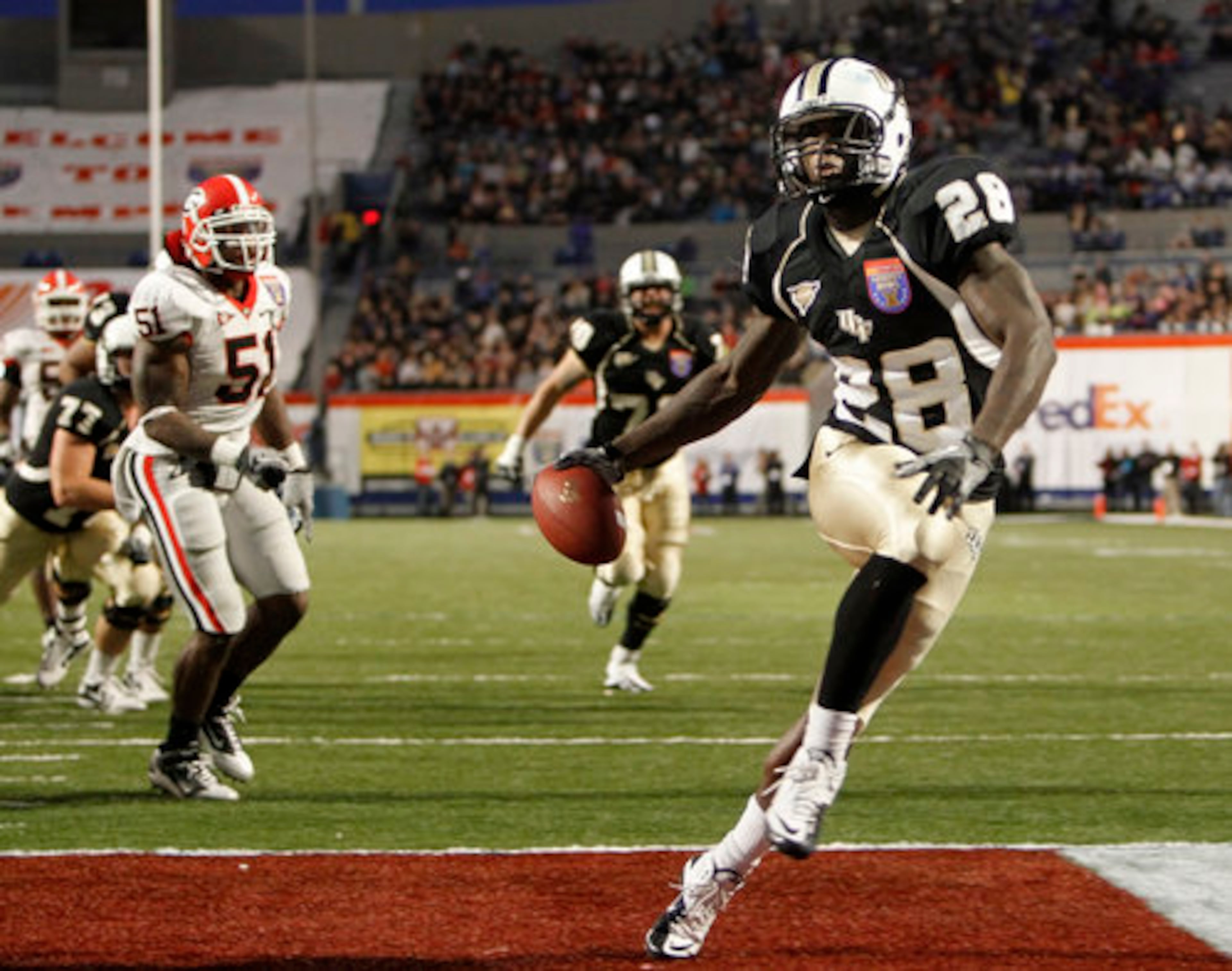 Central Florida running back Latavius Murray (28) scores a touchdown on a 10-yard run against Georgia in the fourth quarter of the Liberty Bowl NCAA college football game Friday, Dec. 31, 2010 in Memphis, Tenn. Central Florida won 10-6. Georgia linebacker Akeem Dent (51) is at left.