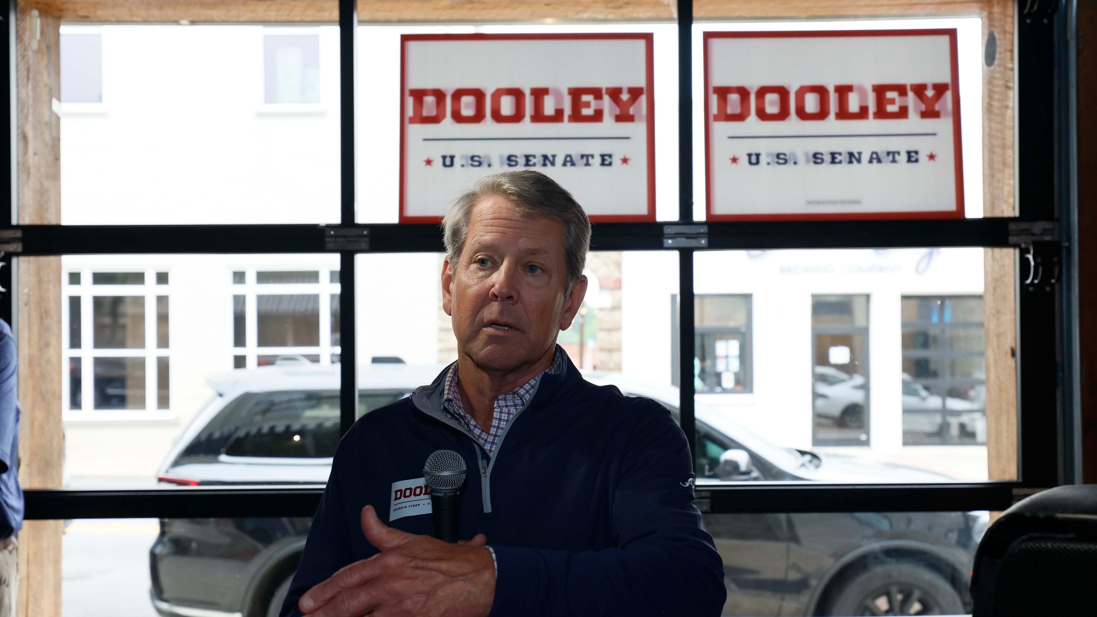Gov. Brian Kemp addresses supporters while campaigning for U.S. Senate candidate Derek Dooley in downtown Carrollton on Monday. (Miguel Martinez/AJC)