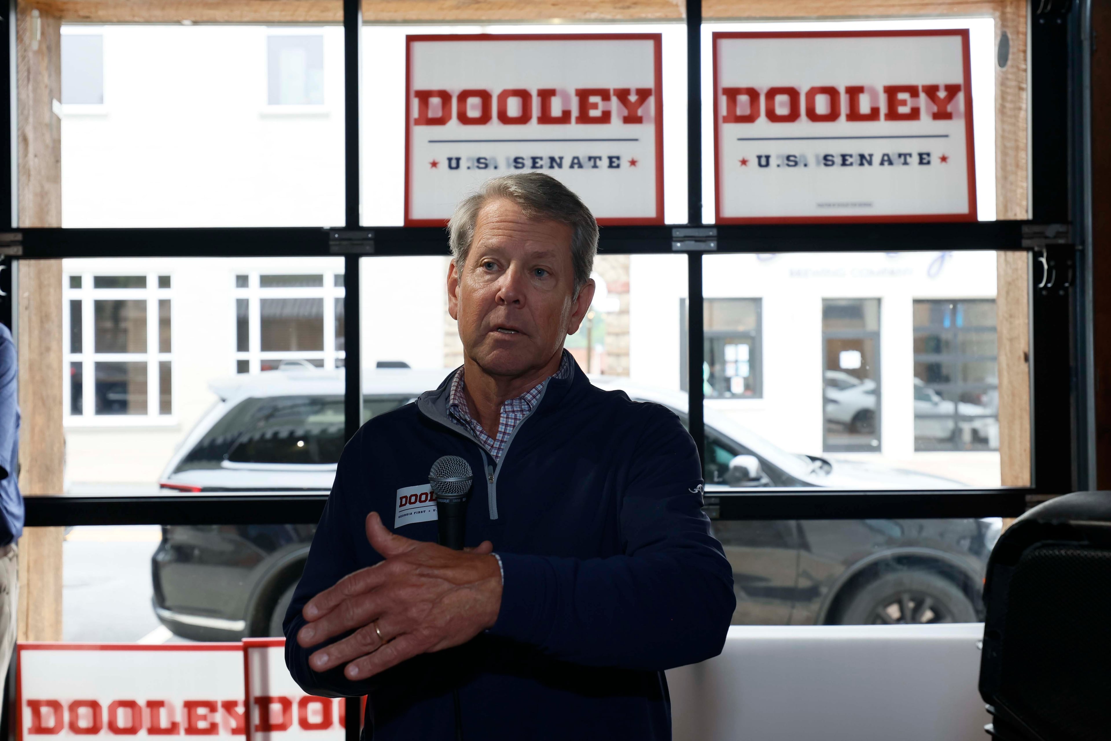 Gov. Brian Kemp addresses supporters while campaigning for U.S. Senate candidate Derek Dooley in downtown Carrollton on Monday. (Miguel Martinez/AJC)