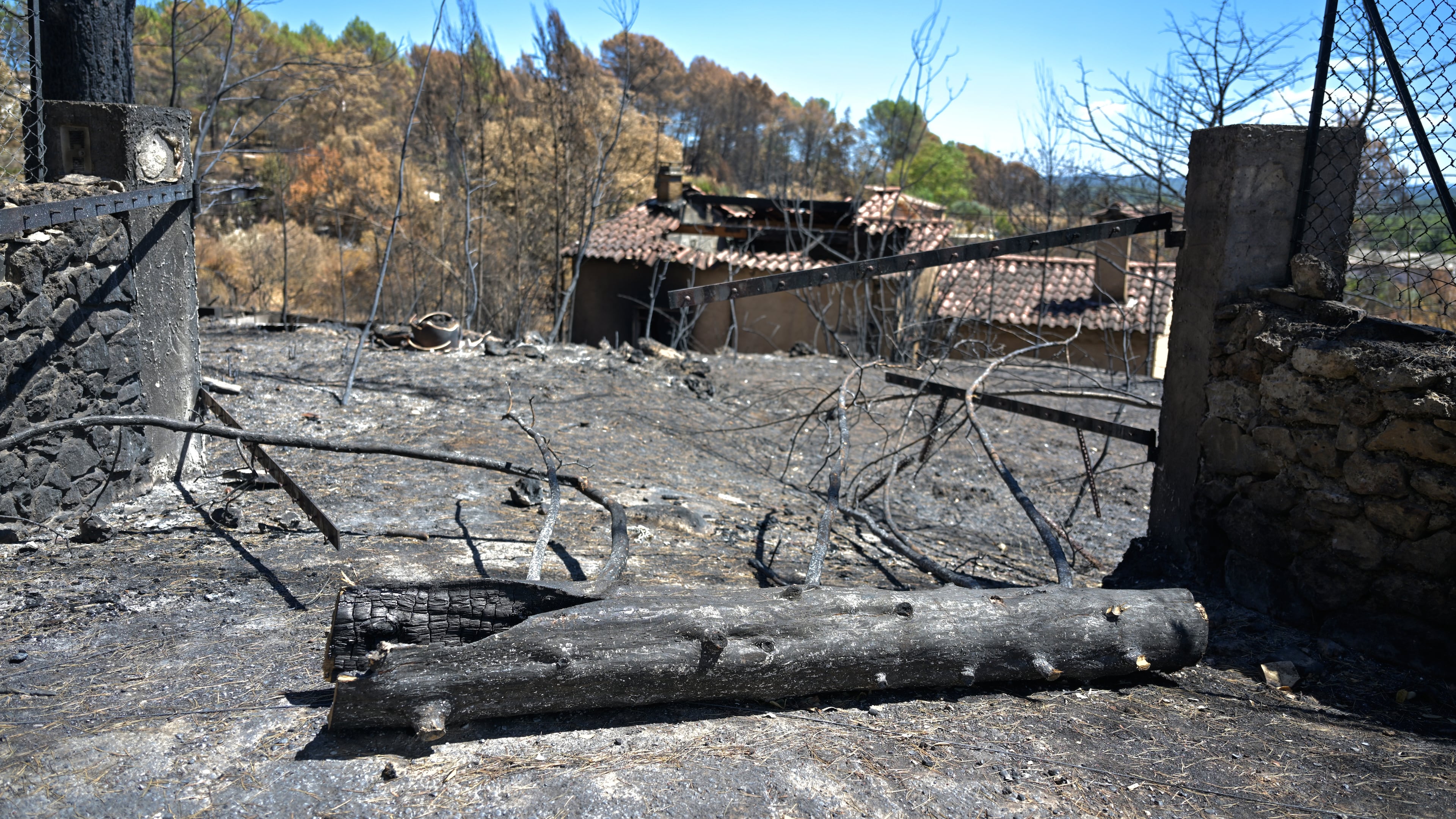 A gate and villa are burned after wildfires in Cotignac, France, Thursday, Aug. 6, 2026, as drought conditions worsen following a heatwave and water shortages across much of France. (AP Photo/Philippe Magoni)