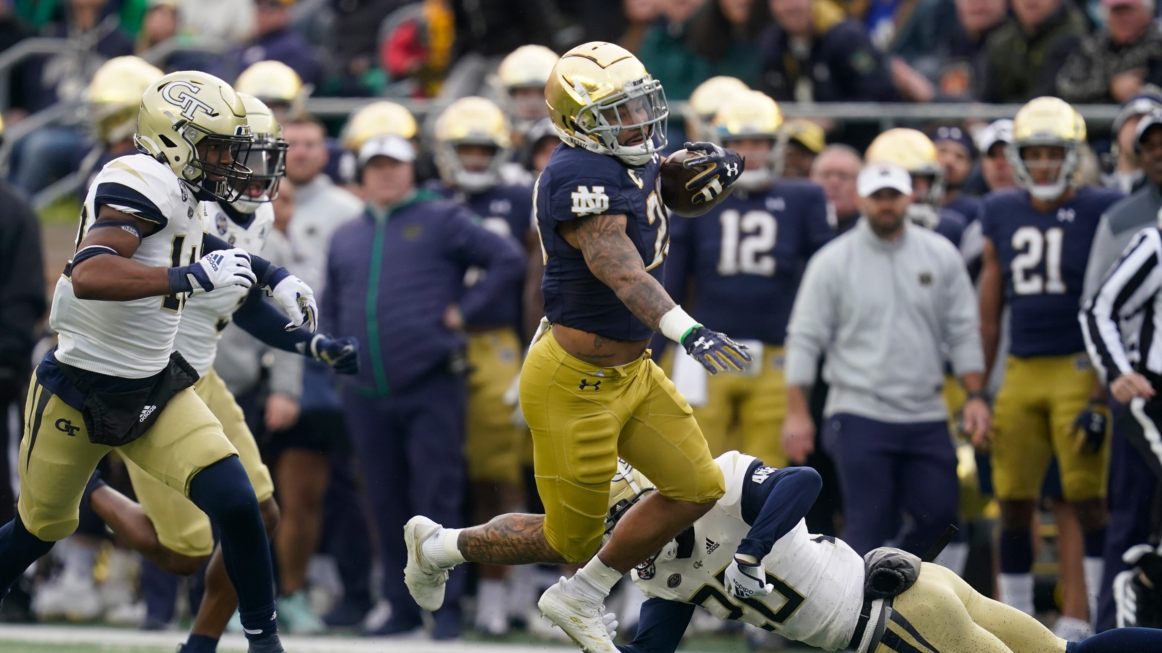 Notre Dame's Kyren Williams (23) runs past Georgia Tech's Miles Brooks (20) during the first half of an NCAA college football game, Saturday, Nov. 20, 2021, in South Bend, Ind. (AP Photo/Darron Cummings)