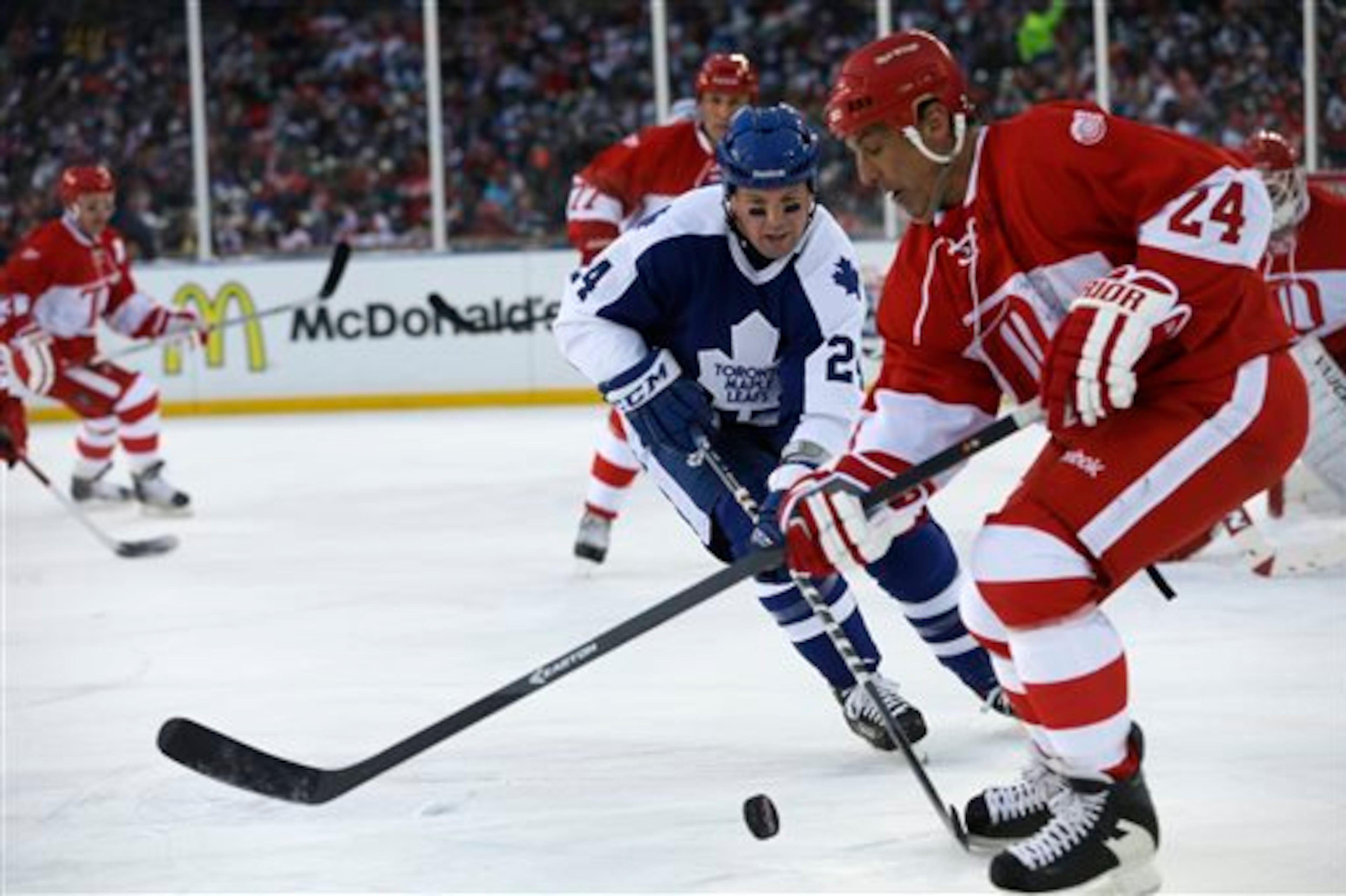 Toronto Maple Leafs defenseman Bryan McCabe closes in on Detroit Red Wings defenseman Chris Chelios during the first period of the Winter Classic Alumni outdoor NHL hockey game at Comerica Park in Detroit, Tuesday, Dec. 31, 2013. (AP Photo/Carlos Osorio)