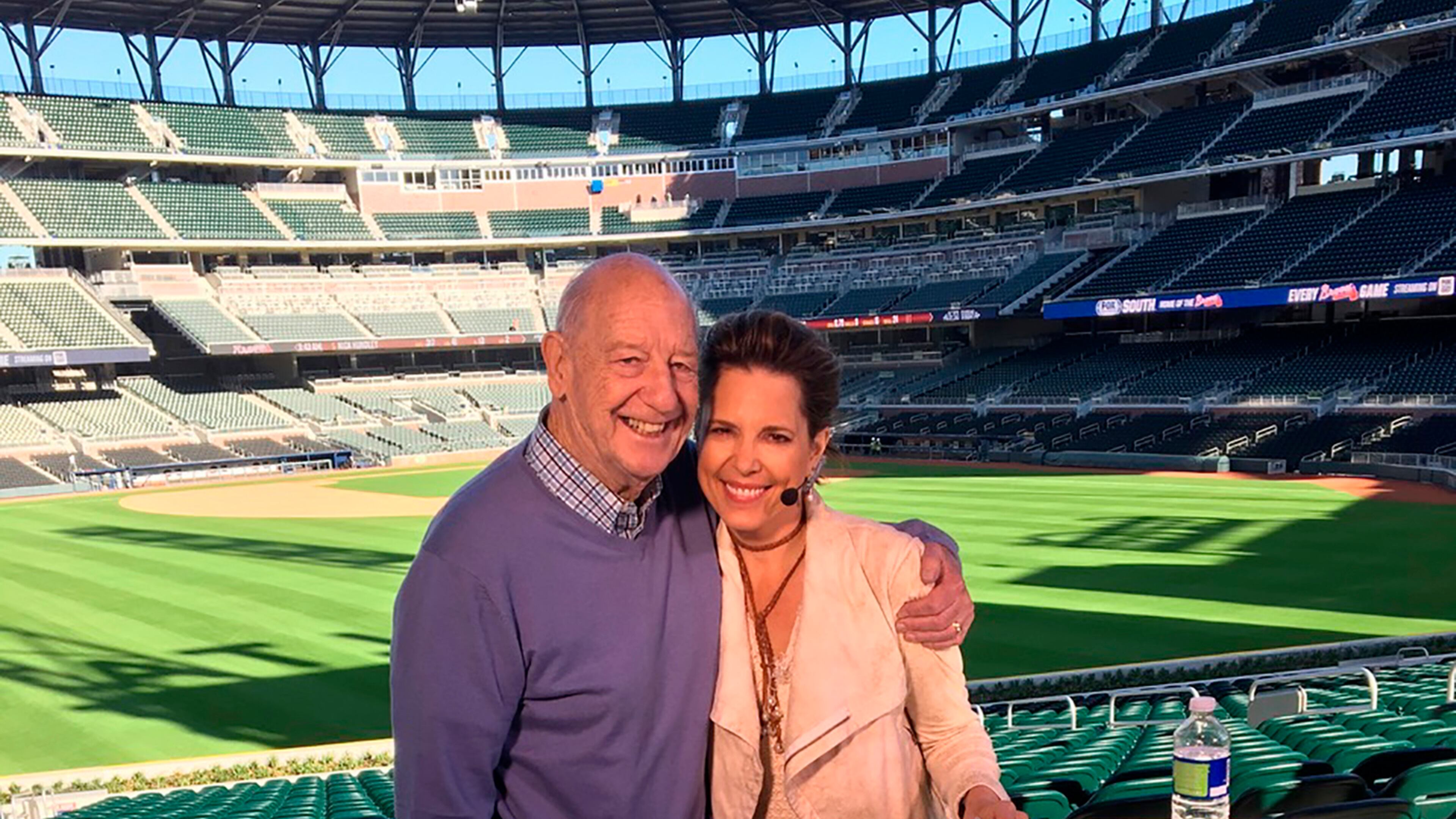 In this March 2017 photo provided by Hannah Storm, Mike Storen poses with daughter Hannah Storm at the Atlanta Braves' new ballpark in Atlanta. Storen, a former ABA commissioner and multisport marketing whiz, died Thursday, May 7, 2020. He was 84. Storm said her father died at Emory University Hospital in Atlanta of complications from cancer. (Courtesy of Hannah Storm via AP)