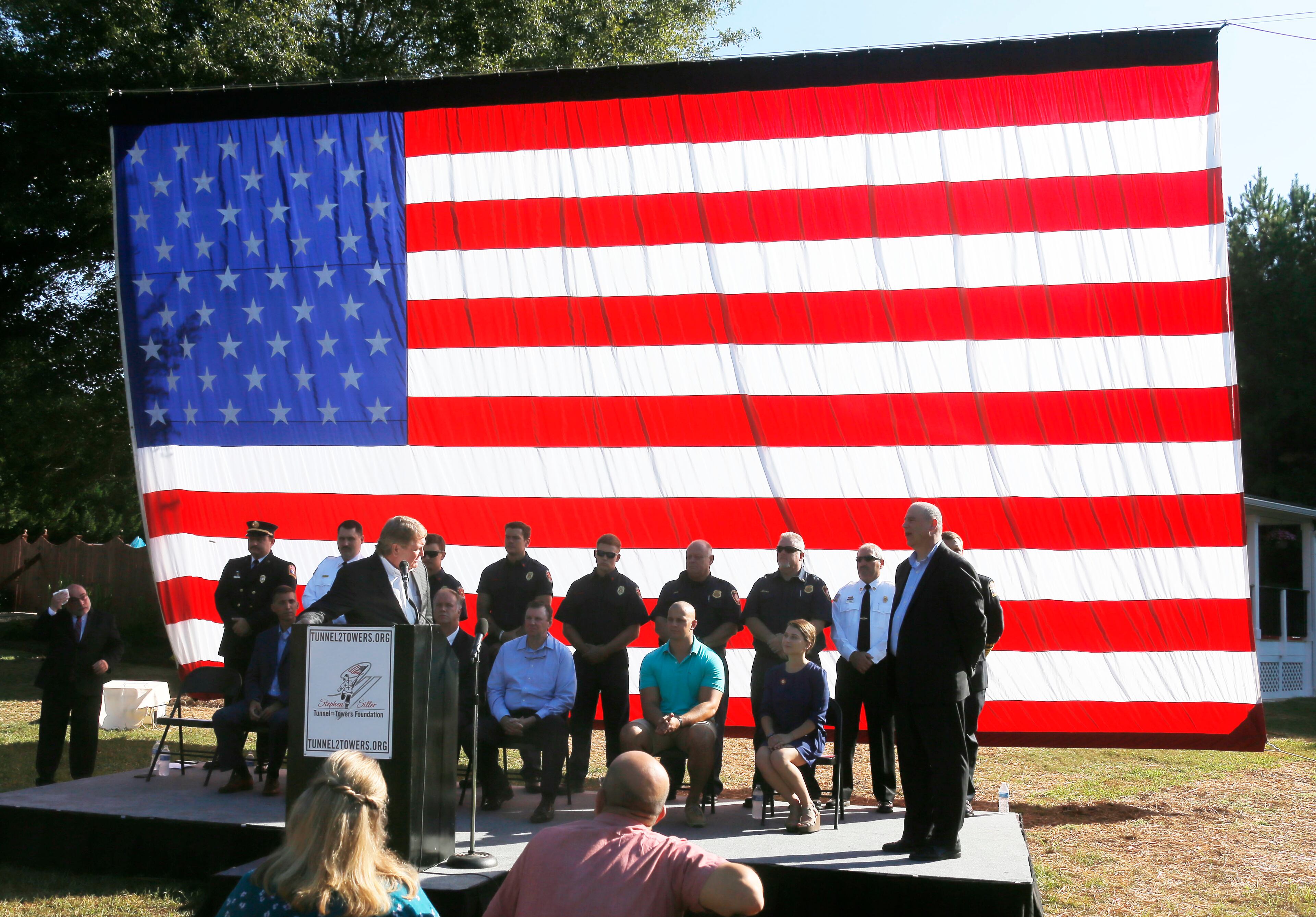 9/11/18 - Barnesville - The ceremony took place in front of a 50 foot American flag that was be pulled back to reveal the home to Sarah and her daughters Willow and Guinevere for the first time. On Tuesday morning in Barnesville, a charity started in honor of a fallen 9/11 firefighter gave a home to the wife and young daughters of Marine Cpl. Collin Schaaff, who has one of 16 who lost their lives last year in a transport plane crash in Mississippi. "Stephen Siller lost his life protecting others on 9/11 and Cpl. Schaaff was killed in the line of duty protecting all Americans, Òsaid Frank Siller, Chairman and CEO of the Tunnel to Towers Foundation. ÒIf it weren't for the attacks on the World Trade Center, Cpl. Schaaff would not have been in harmÕs way, and would still be here to be a husband and father.Ó BOB ANDRES /BANDRES@AJC.COM