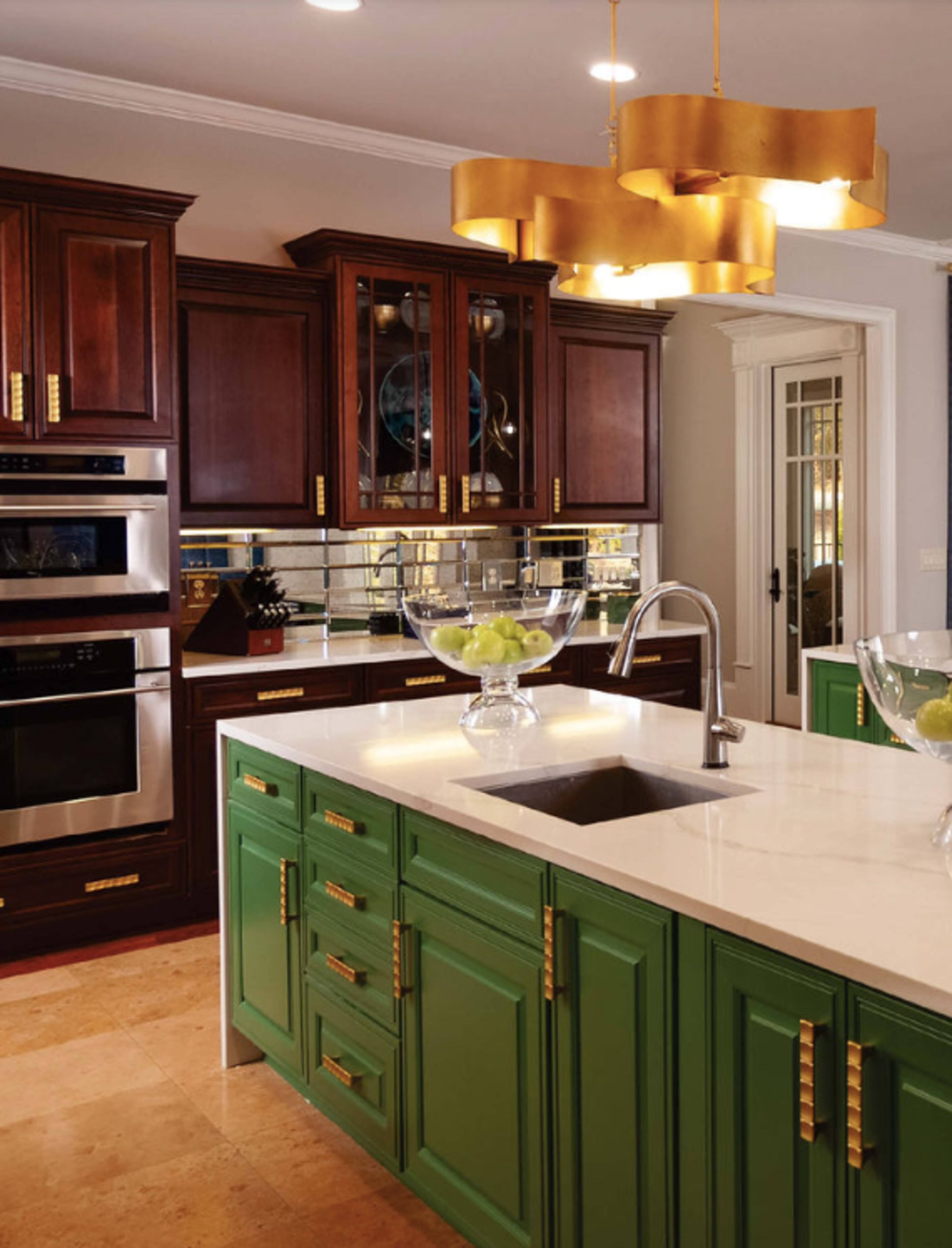 The sisters removed a row of cabinets above the island to open up the kitchen area and added new light fixtures and gold hardware to modernize the look.