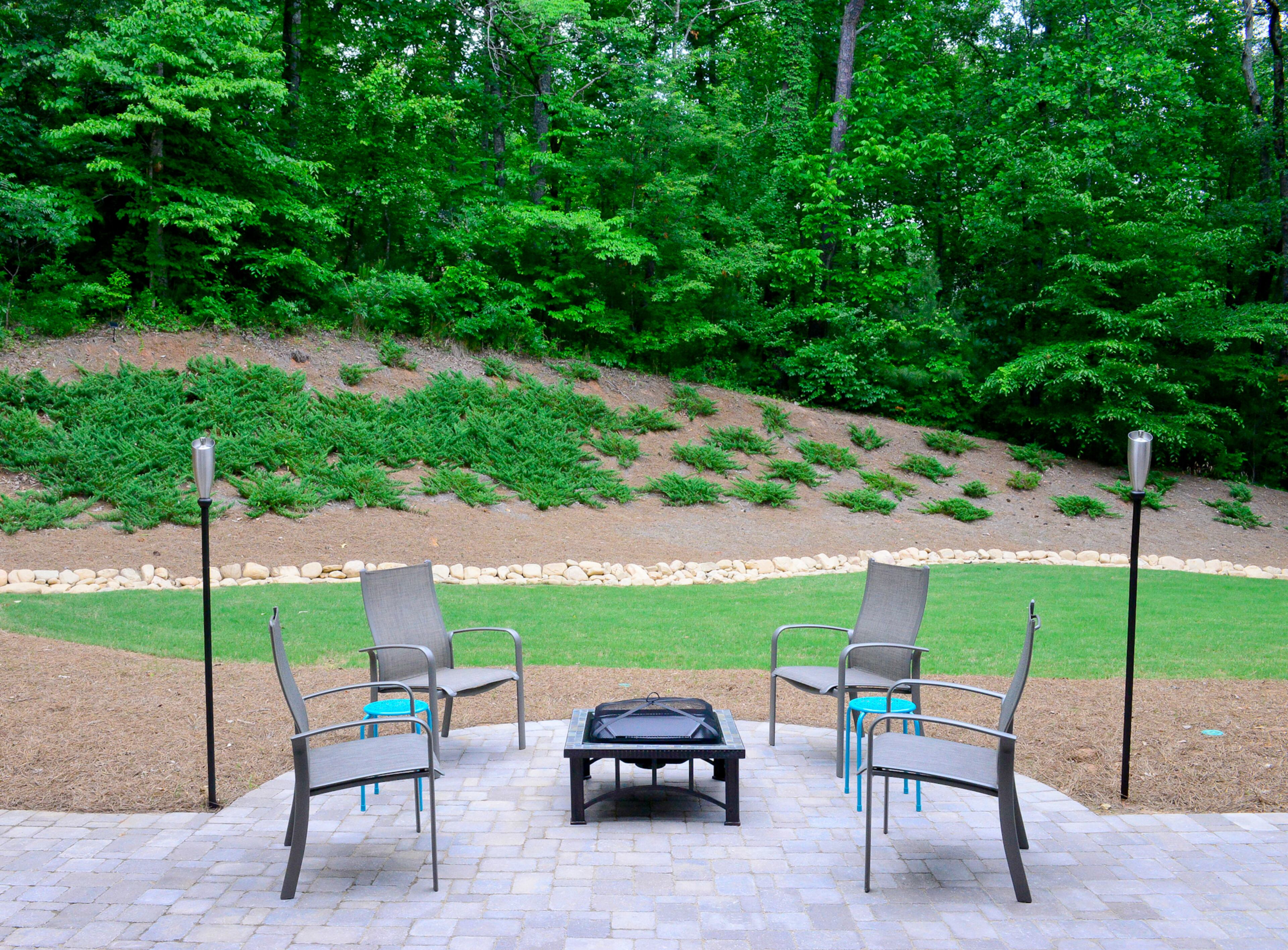 A new paver patio, built by Ashman Landscape Group, now provides a place for the family and their friends to sit around the fire pit. Ashman also helped the homeowners solve drainage issues, by creating a dry riverbed of various sized rocks running through the backyard.