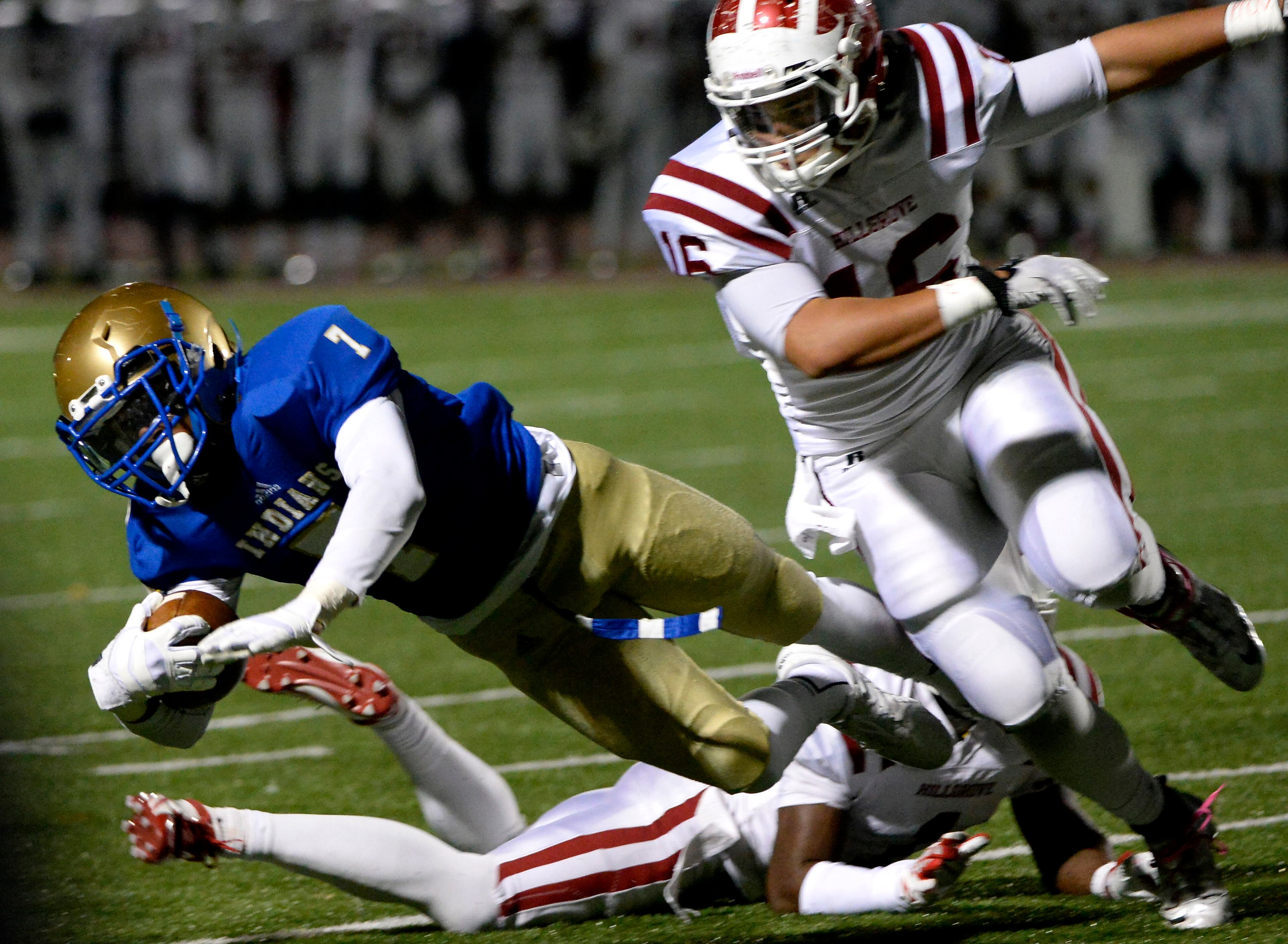 McEachern's Taj Griffin is tackled by Hillgrove's Conner Beck (16) in the first half of their high school football game at Cobb Energy Field on Friday, Nov. 8, 2013, in Powder Springs, Ga.