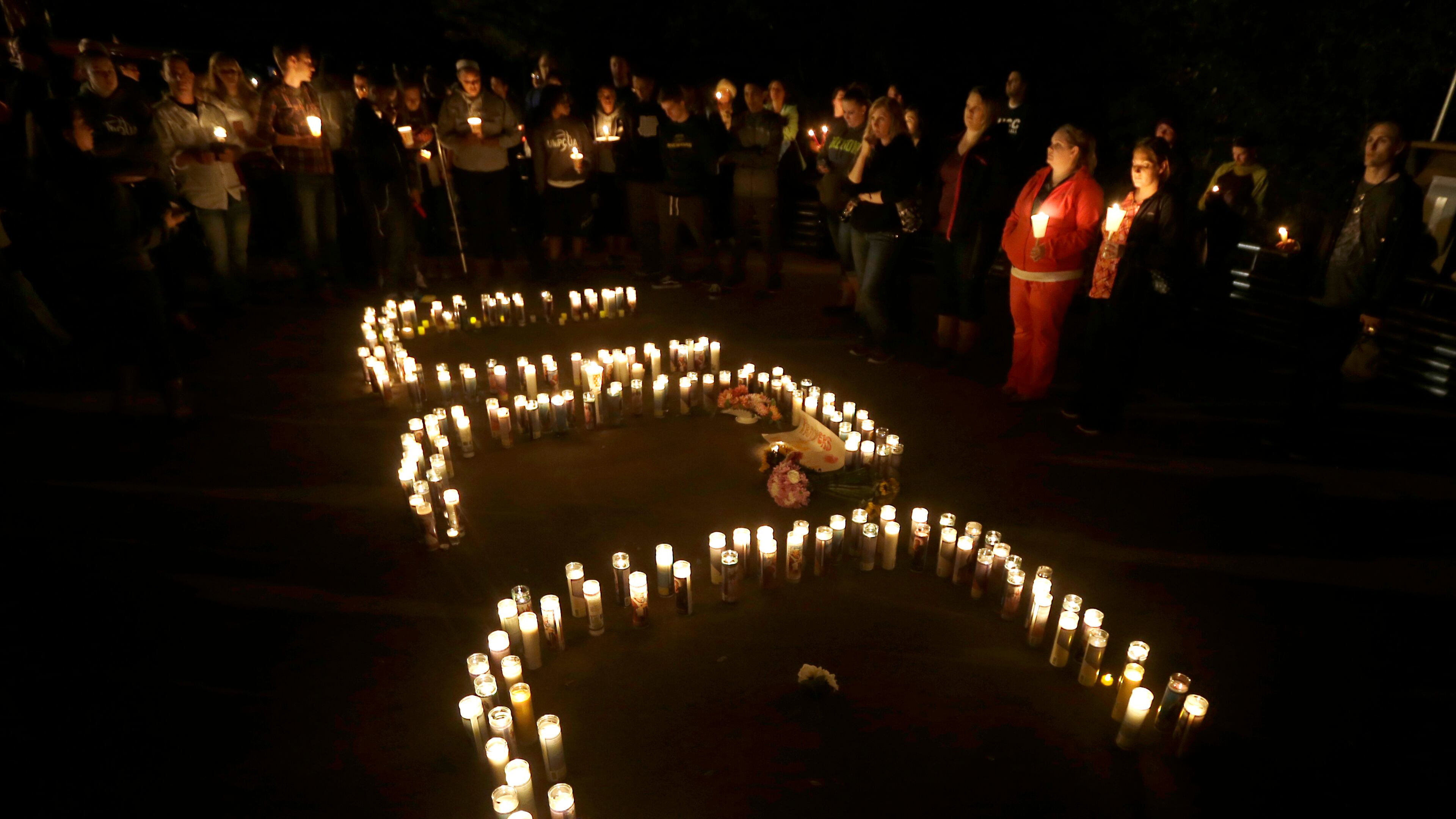 Candles spelling UCC for Umpqua Community College, are displayed at a candlelight vigil for those killed during a fatal shooting at the school, Thursday, Oct. 1, 2015, in Roseburg, Ore. (AP Photo/Rich Pedroncelli)