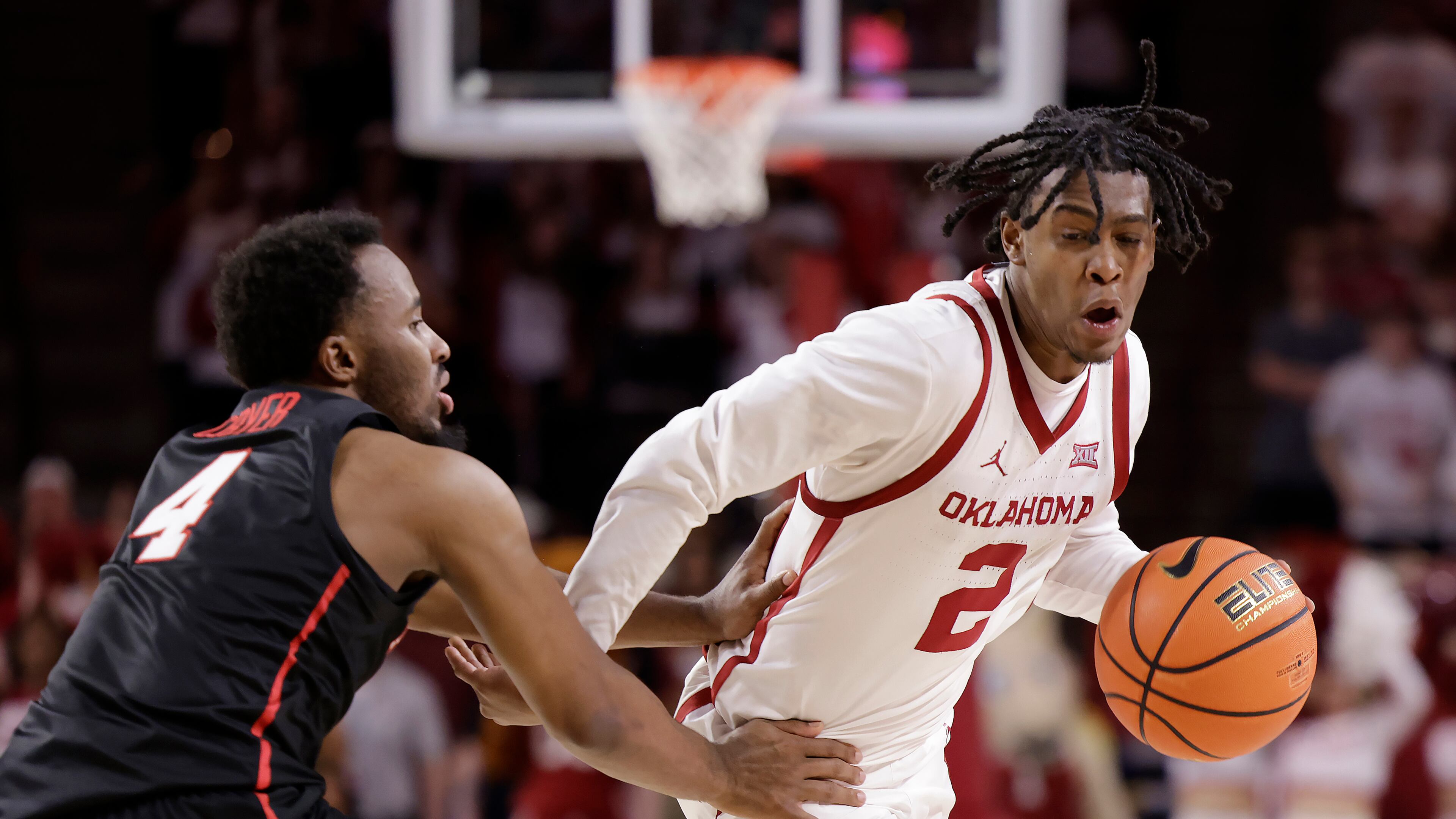 Oklahoma guard Javian McCollum (2) is defended by Houston guard L.J. Cryer (4) during the second half of an NCAA college basketball game Saturday, March 2, 2024, in Norman, Okla. (AP Photo/Garett Fisbeck)