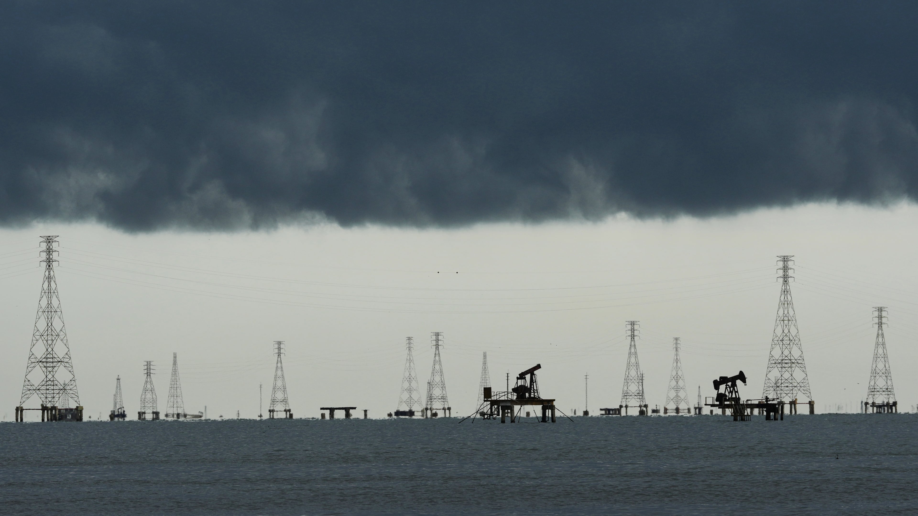 Clouds form over pumpjacks and power transmission towers on Lake Maracaibo in Cabimas, Venezuela, Tuesday, Sept. 1, 2026. (AP Photo/Ariana Cubillos)