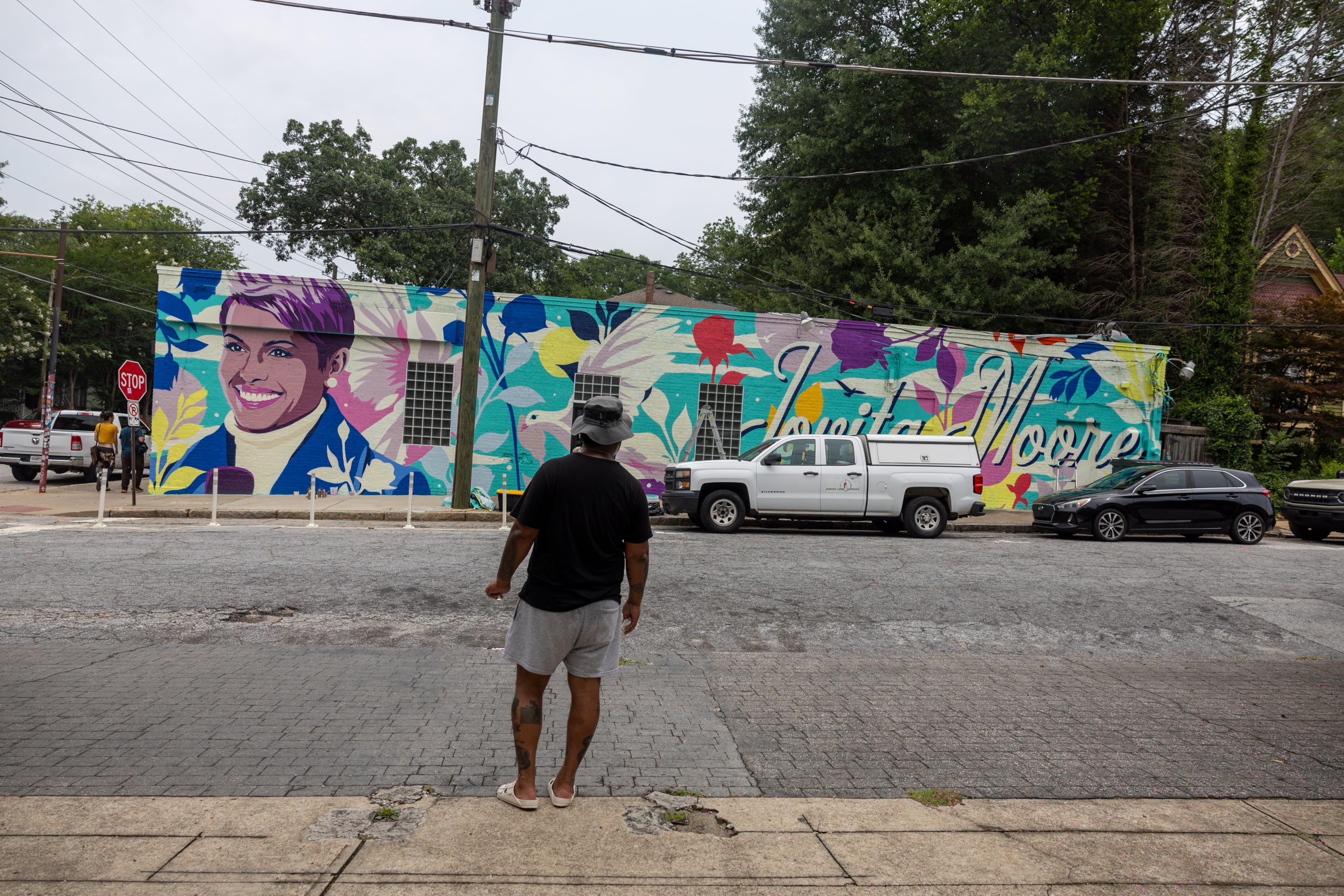 Artist Tommy Bronx looks over his new mural honoring the late news anchor Jovita Moore on the side of Bellwood Coffee in Atlanta on July 29, 2026. The coffee shop created community outcry when it painted over the original mural of Moore. (Arvin Temkar/AJC)