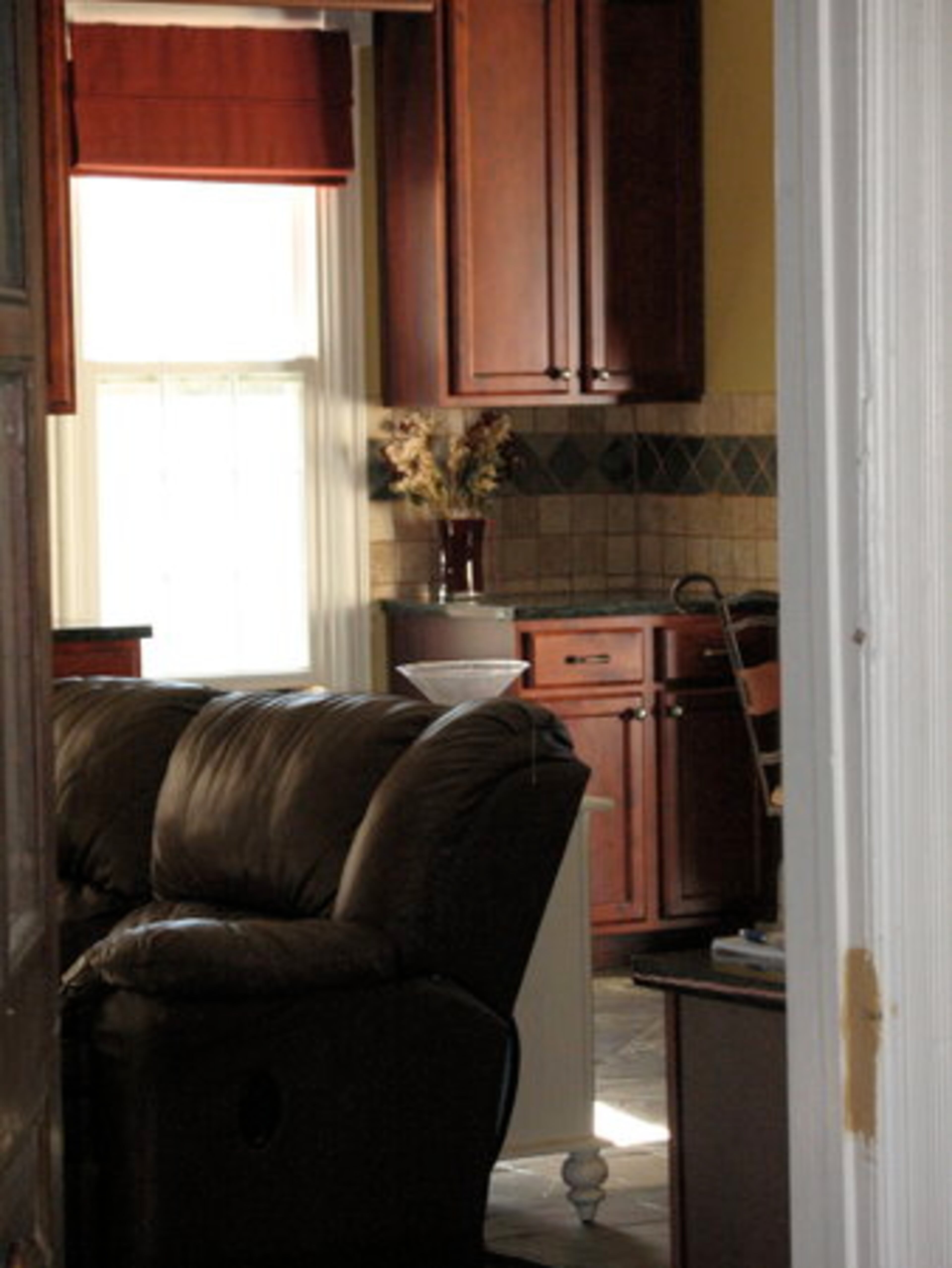 Another view of the living room leading in to the kitchen. The couple painted, tiled, knocked down walls, sanded floors and replaced almost 40 windows.
