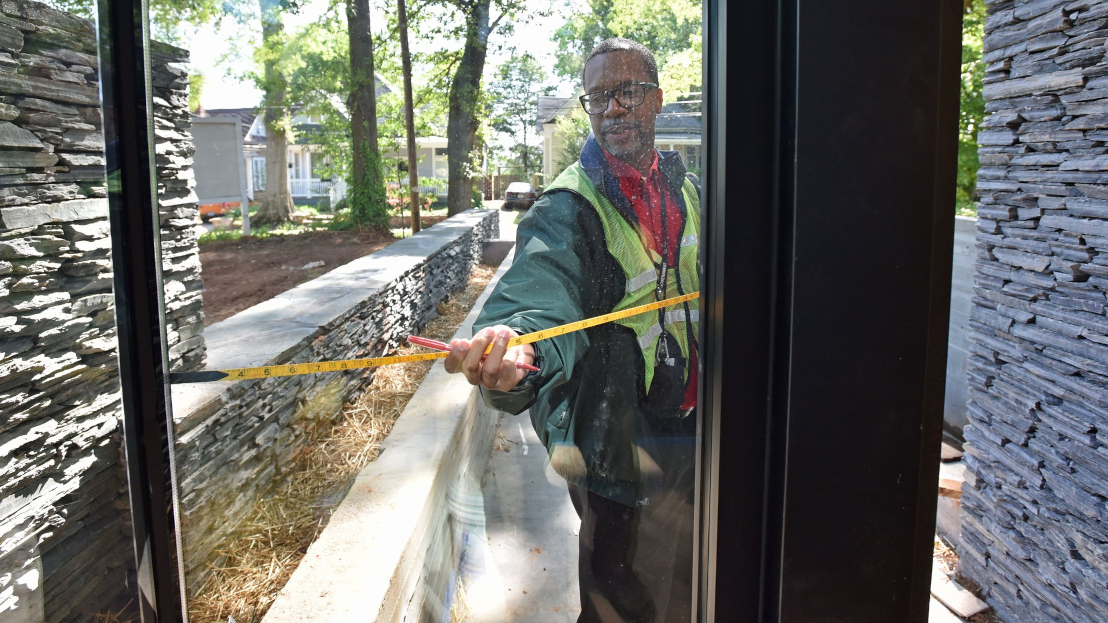 Paul Walker takes outside measurements as he appraises a new home for Fulton County. Overall, the county expects taxable values to increase 5 percent this year. HYOSUB SHIN / HSHIN@AJC.COM