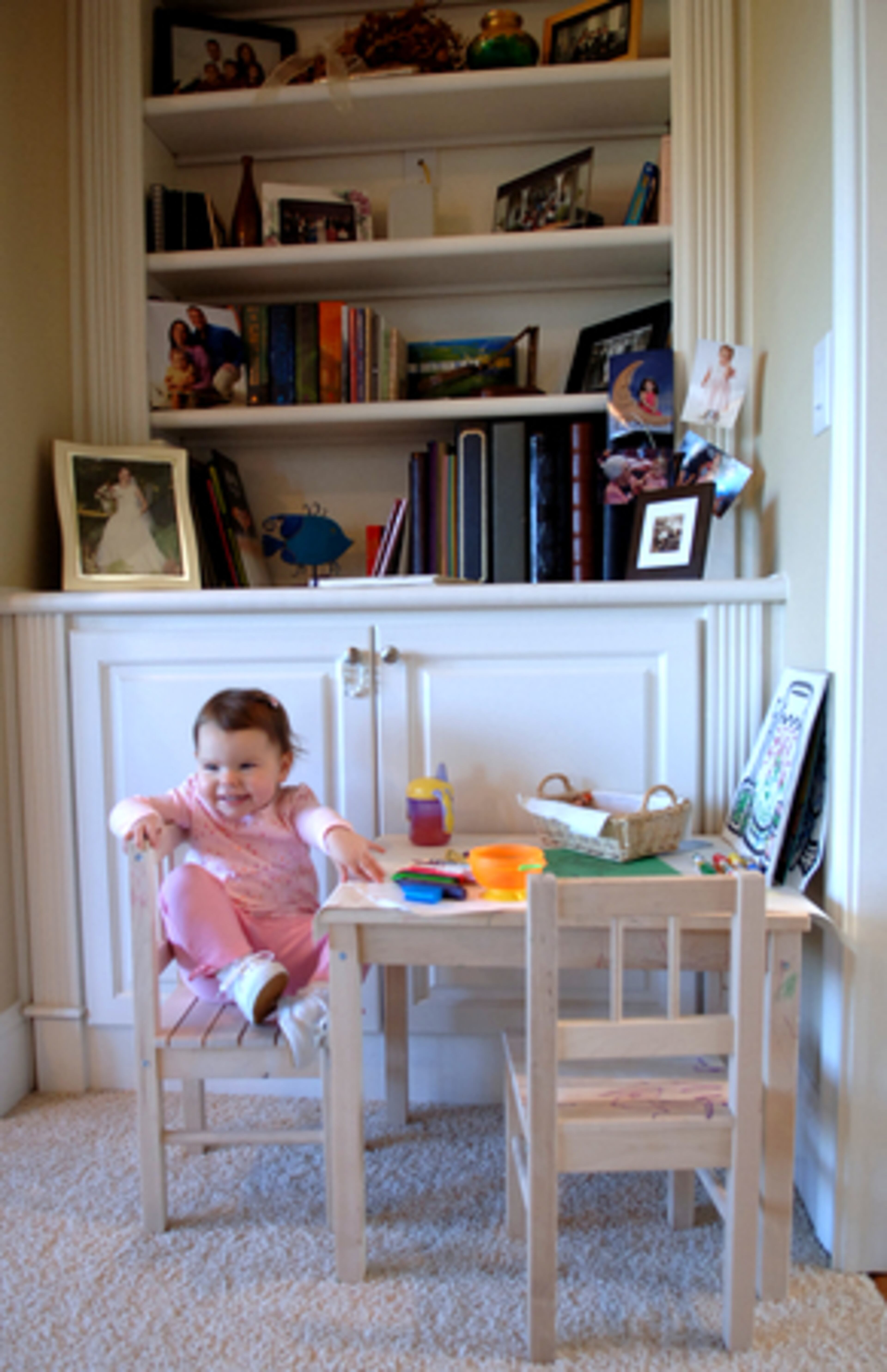 Claire sits at her art table in the corner of the living room.