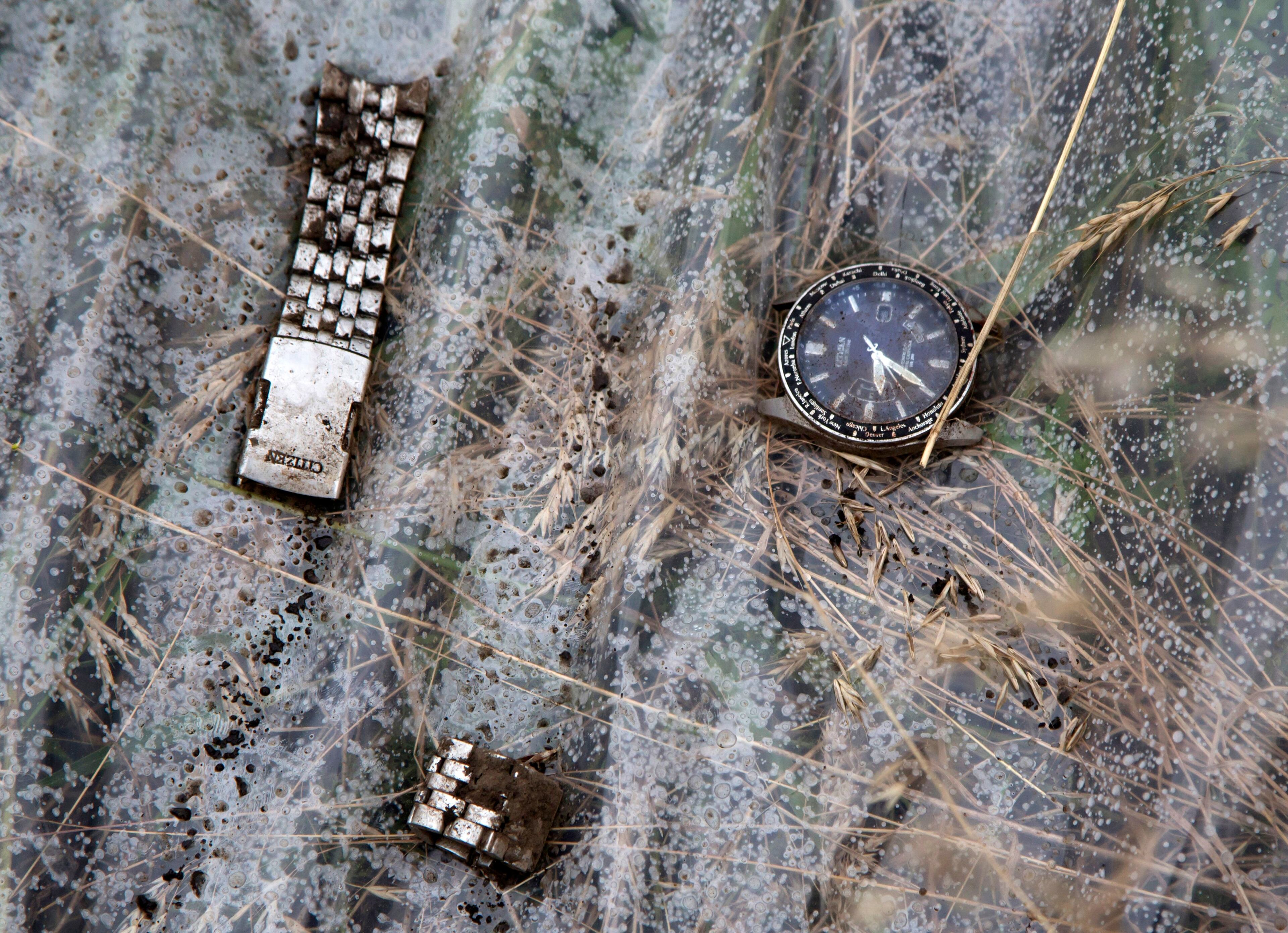 A watch and a part of bracelet lie on a plastic cover at the site of a crashed Malaysia Airlines passenger plane near the village of Rozsypne, Ukraine, eastern Ukraine Friday, July 18, 2014. Rescue workers, policemen and even off-duty coal miners were combing a sprawling area in eastern Ukraine near the Russian border where the Malaysian plane ended up in burning pieces Thursday, killing all 298 aboard. (AP Photo/Dmitry Lovetsky)