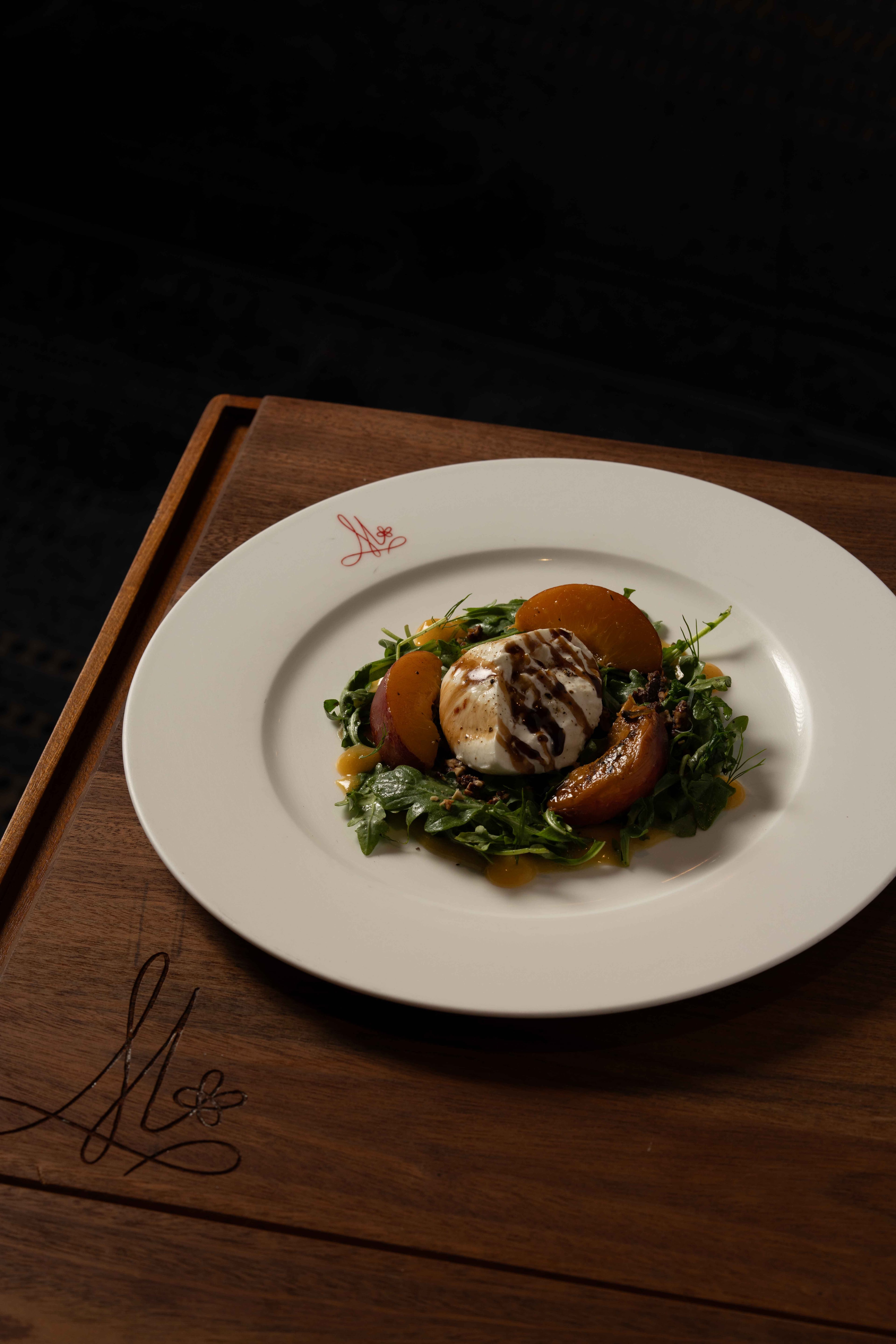 Salade de peches at Brasserie Margot in the Four Seasons Hotel Atlanta: burrata and roasted peach salad with candied pecans and balsamic vinaigrette. (Courtesy of Sonder Media)