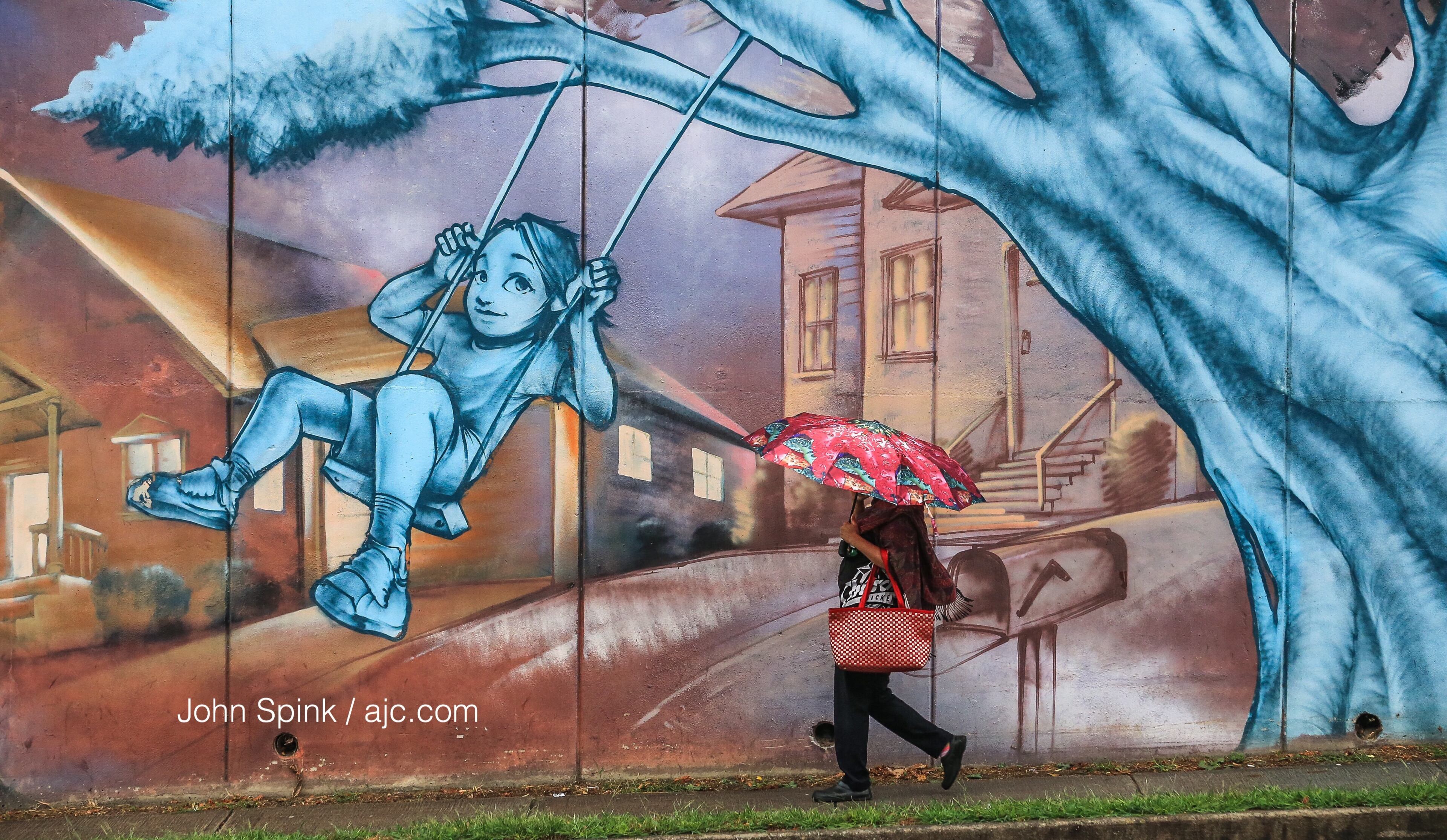Roni Khanam makes her way in the rain along Chamblee Dunwoody Road in DeKalb County on Tuesday morning. JOHN SPINK / JSPINK@AJC.COM