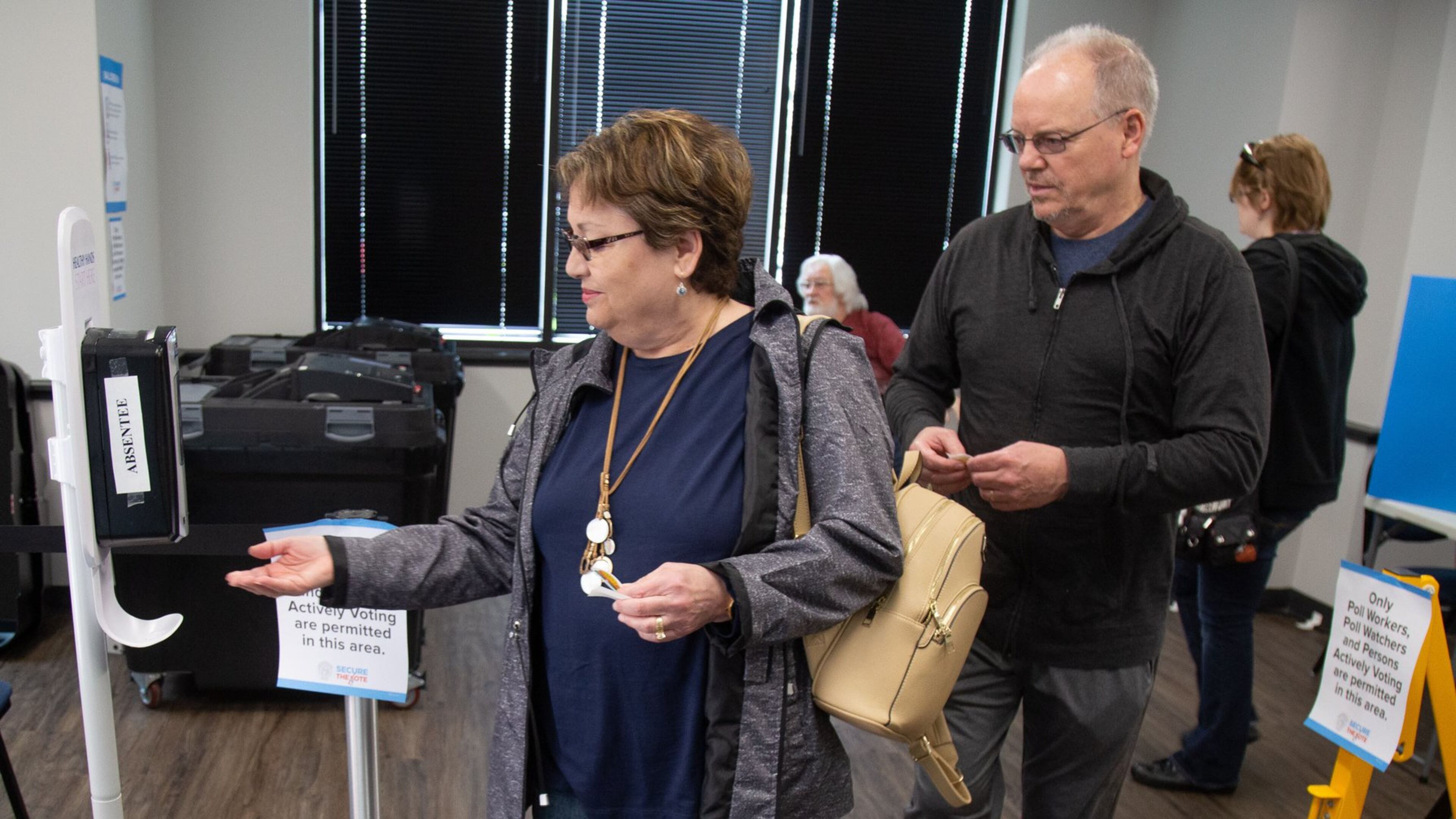 Sheri and James Marshall sanitize their hands after voting at the Marietta polling station during Saturday’s early voting on March 14, 2020. STEVE SCHAEFER / SPECIAL TO THE AJC