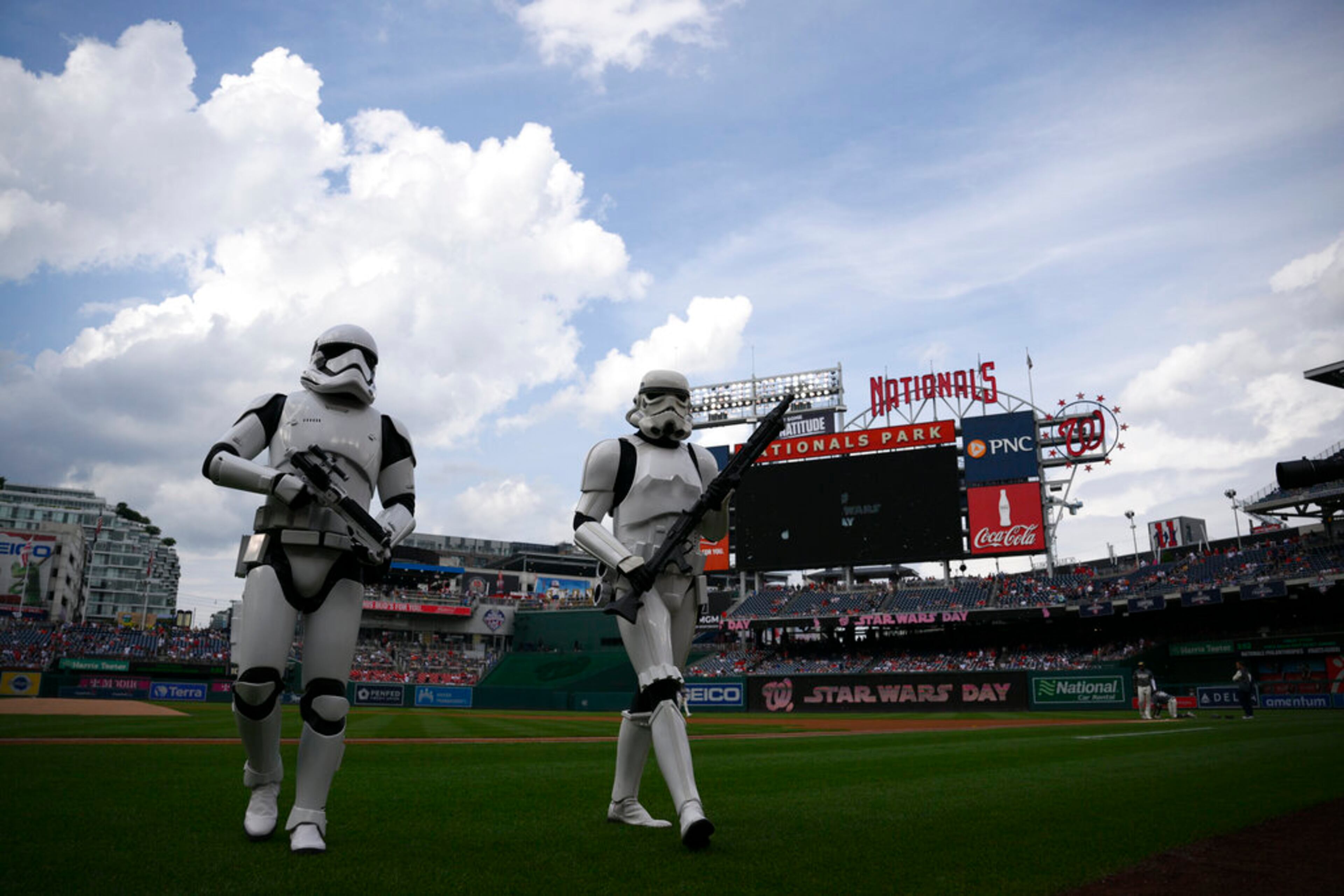 People dressed as stormtrooper characters as part of Star Wars day walk on the field before a baseball game between the Washington Nationals and the Atlanta Braves, Saturday, July 16, 2022, in Washington. (AP Photo/Nick Wass)