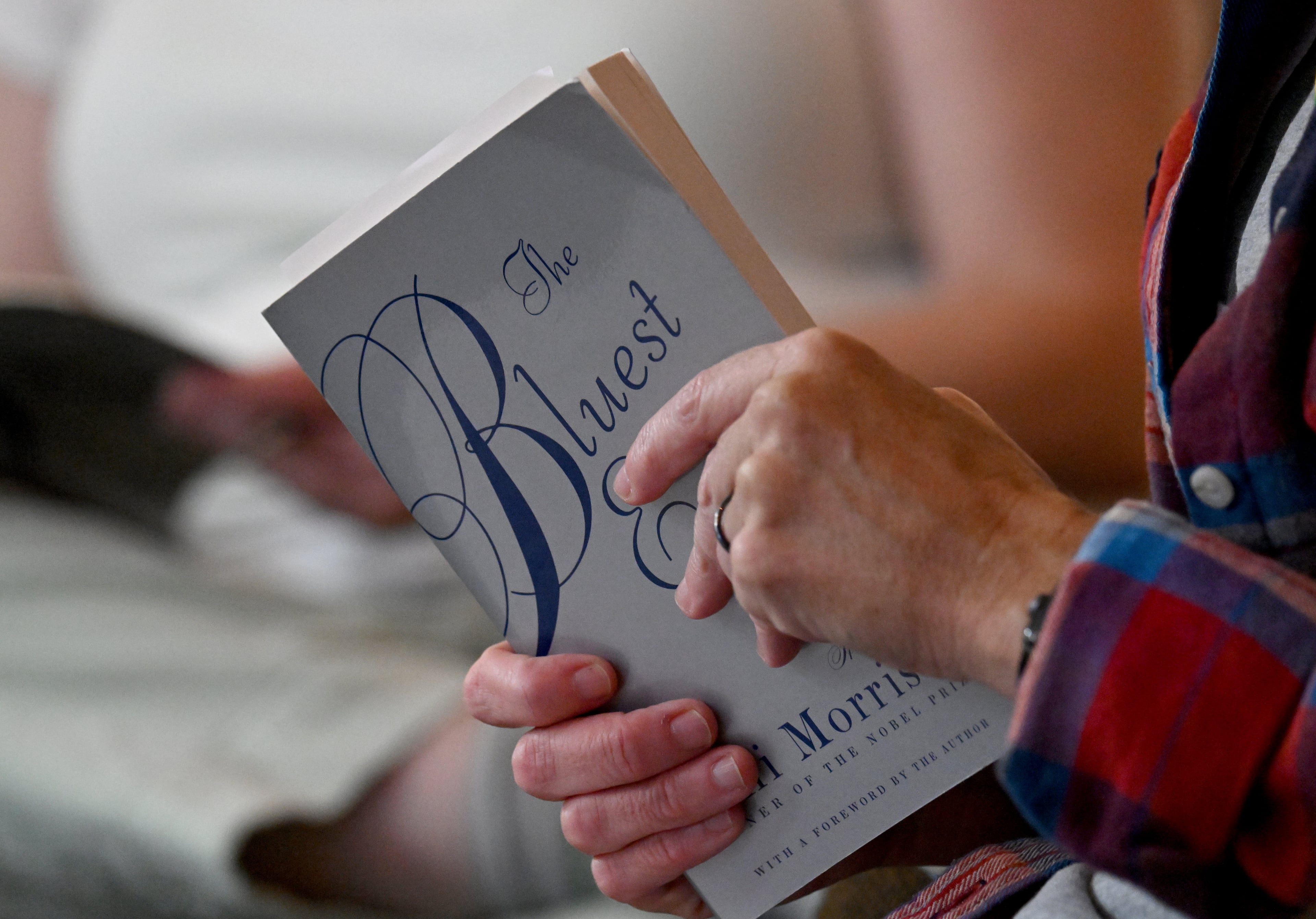 Candace Rowell holds "The Bluest Eye" by Toni Morrison at a Banned Book Club meeting at Virginia-Highland Church on Sept. 19, 2024, in Atlanta. (Hyosub Shin/AJC)