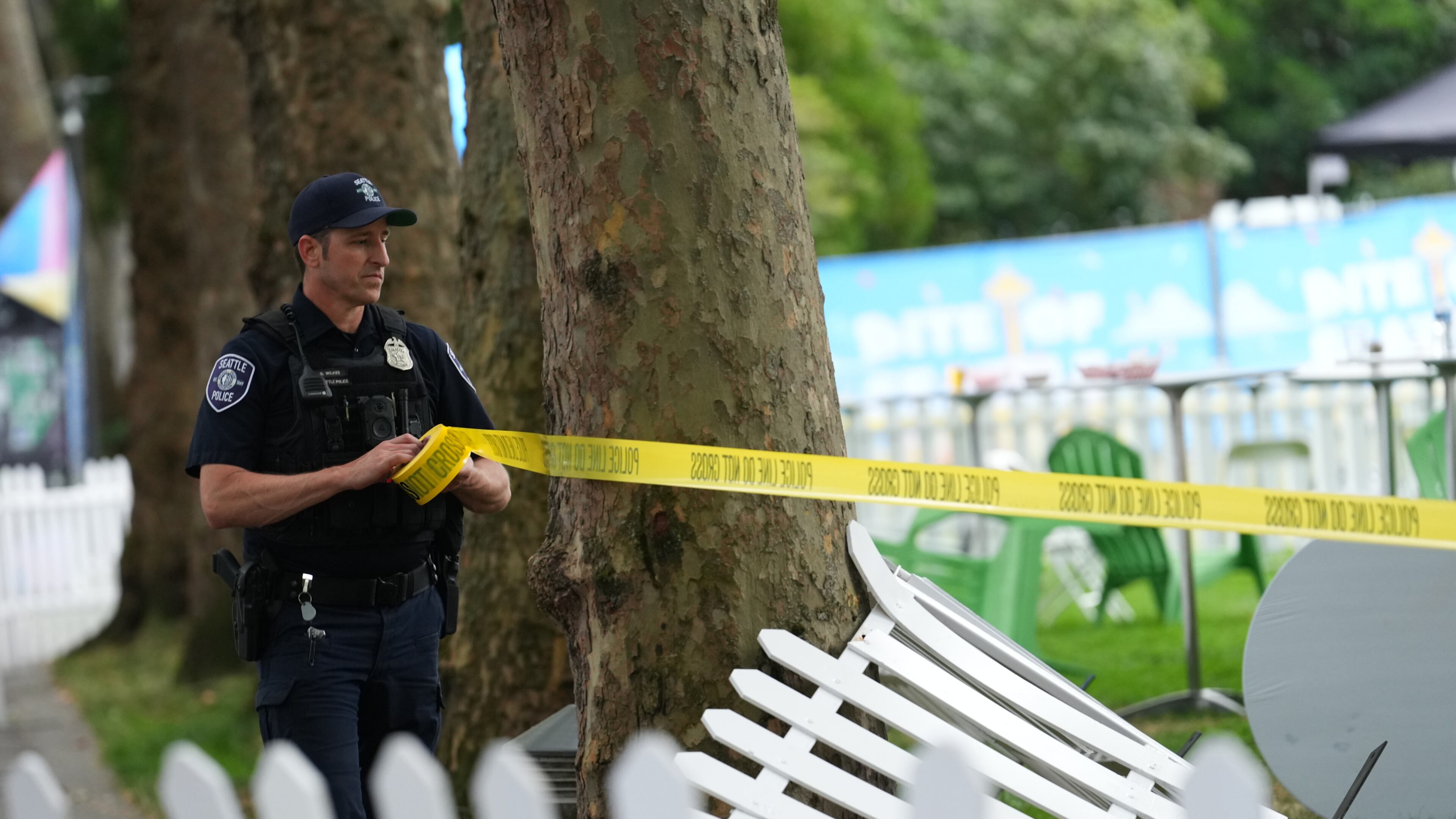 A Seattle Police officer sets up police line tape at the site of a shooting at Seattle Center during the Bite of Seattle food festival Sunday, July 26, 2026, in Seattle. (AP Photo/Lindsey Wasson)