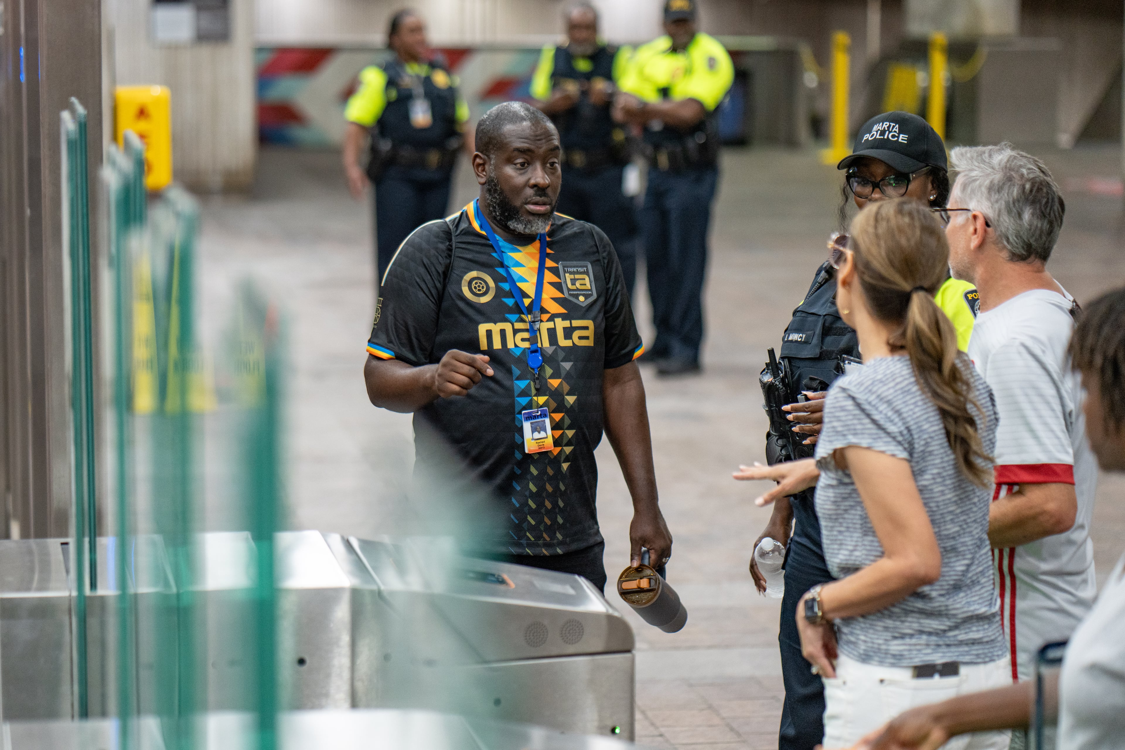 A MARTA Ambassador helps a man and woman Inside the SEC District MARTA station as fans attend the first FIFA match held in Atlanta on Monday, June 15, 2026. (Ben Hendren for the AJC)