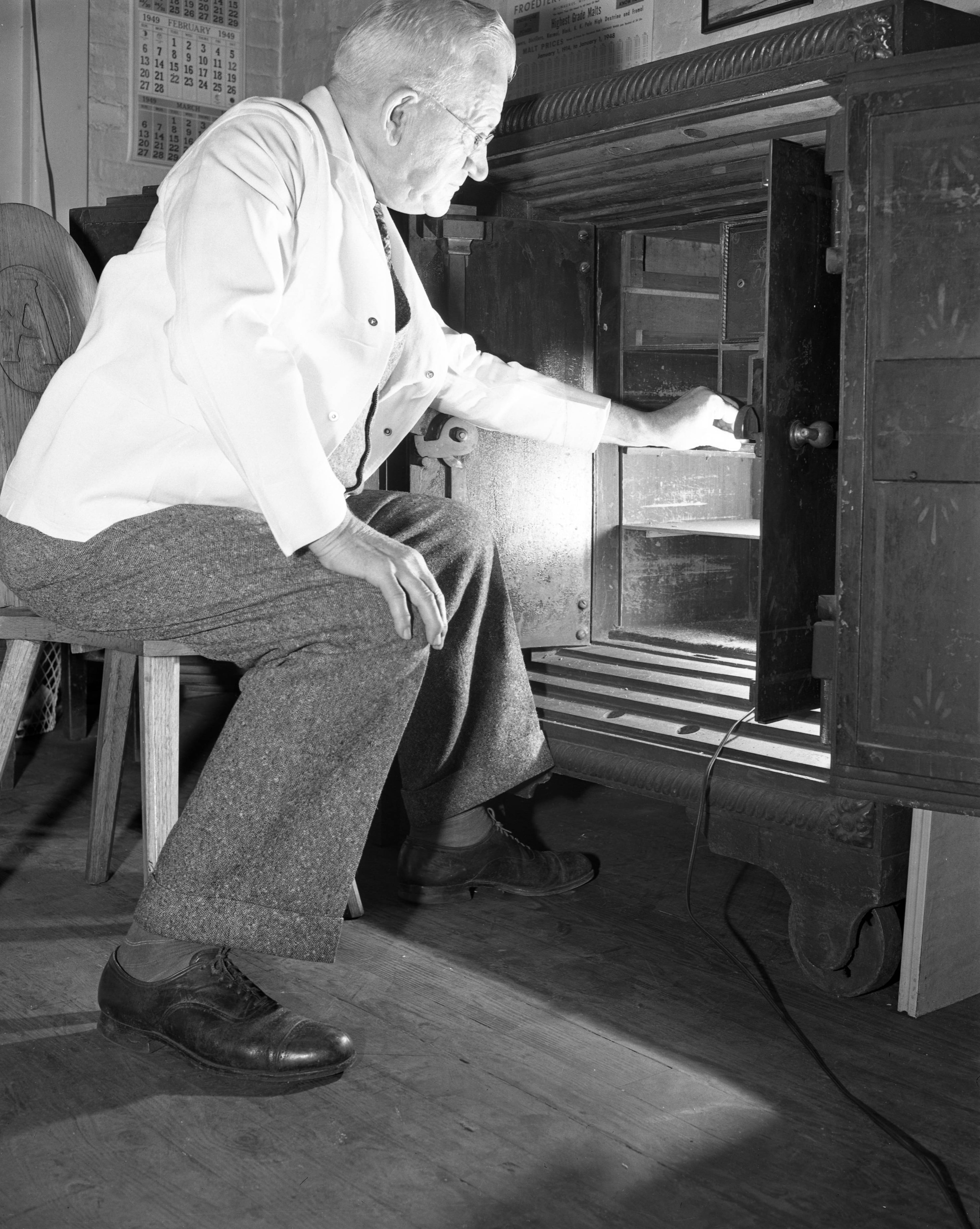 The original caption for this photo reads: "He keeps the 'Schweitzer-ized' secret: Alois R. Reis, Atlantic Co. brewmaster, reaches for the secret formula of the new process beer featured by the company. He alone has access to the valuable paper." Accenting the hops in light beers via water treatment accounted for the special "Schweitzer-izing" that Atlantic used. -- Information from "Atlanta Beer: A Heady History of Brewing in the Hub of the South."
