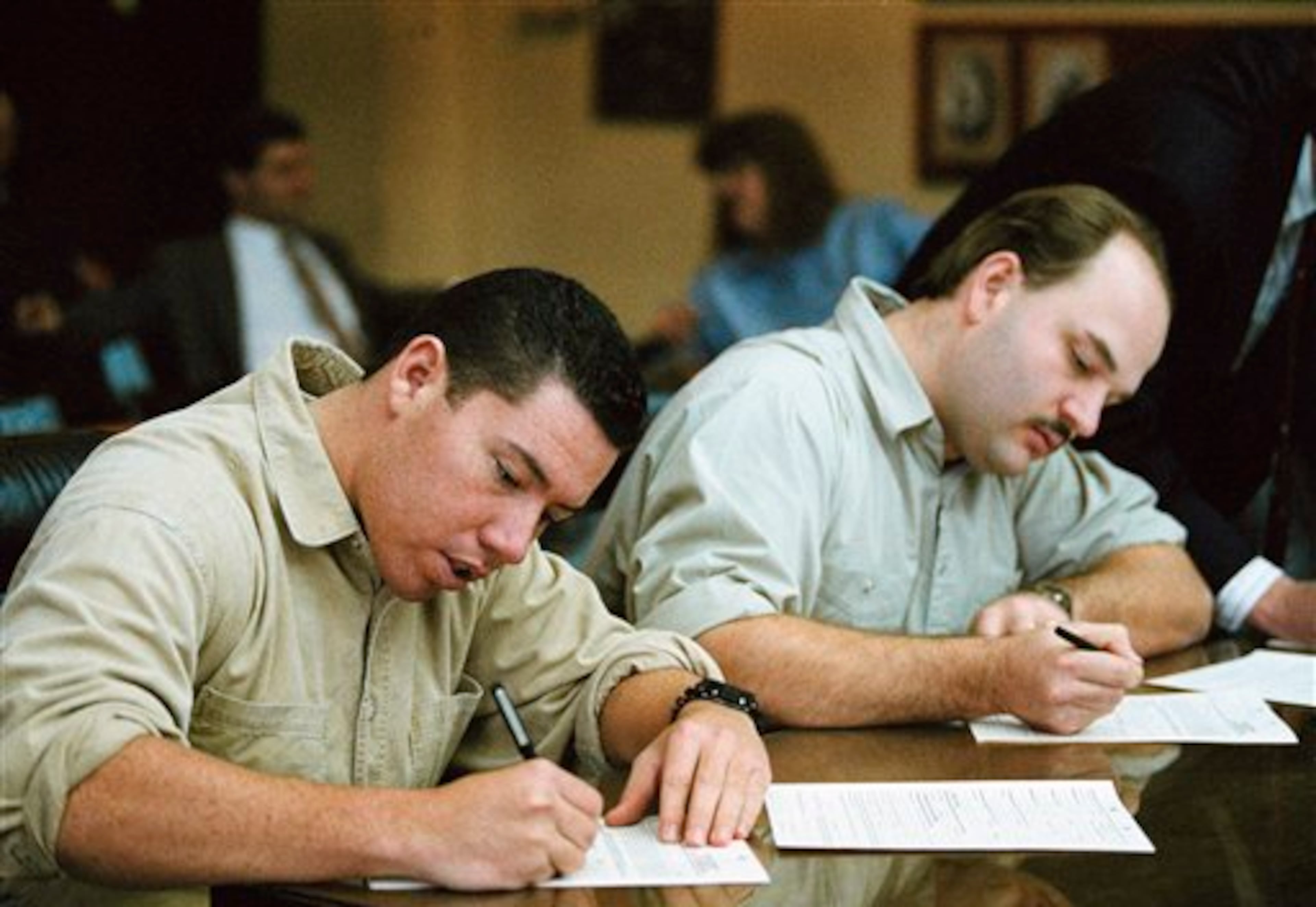Suspects in the Nancy Kerrigan assault case Shane Stant, left, and Derrick Smith, center, sign paper requesting new lawyers in Multnomah County Circuit Court, Portland, Oregon, on Jan. 21, 1994. The judge granted the requests, and court appointed lawyers were assigned in the case. (AP Photo/Jack Smith)