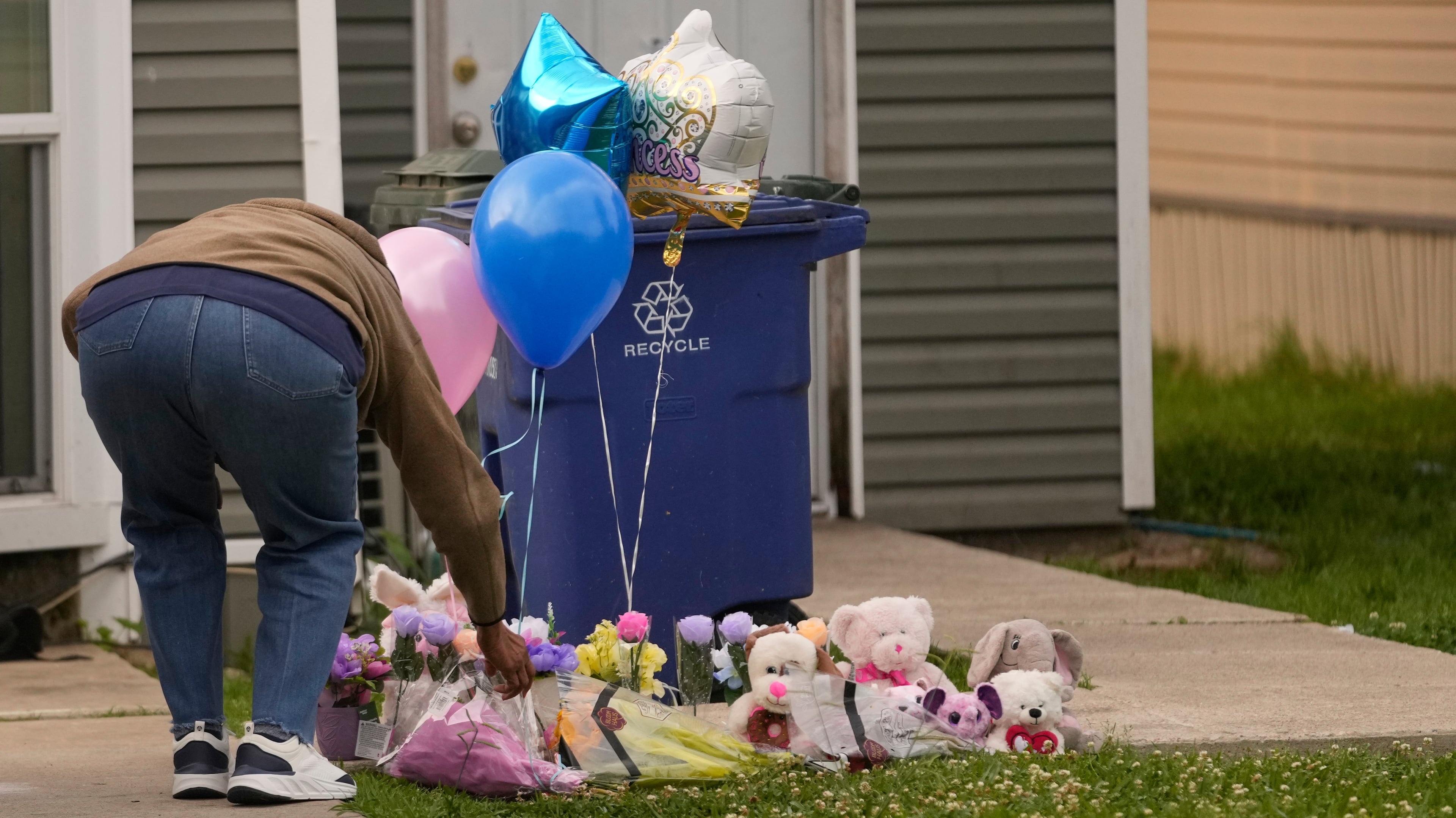 A person leaves a gift at a makeshift memorial on the front lawn of the home where children were killed during a mass shooting the day before in Shreveport, La., Monday, April 20, 2026. (AP Photo/Gerald Herbert)