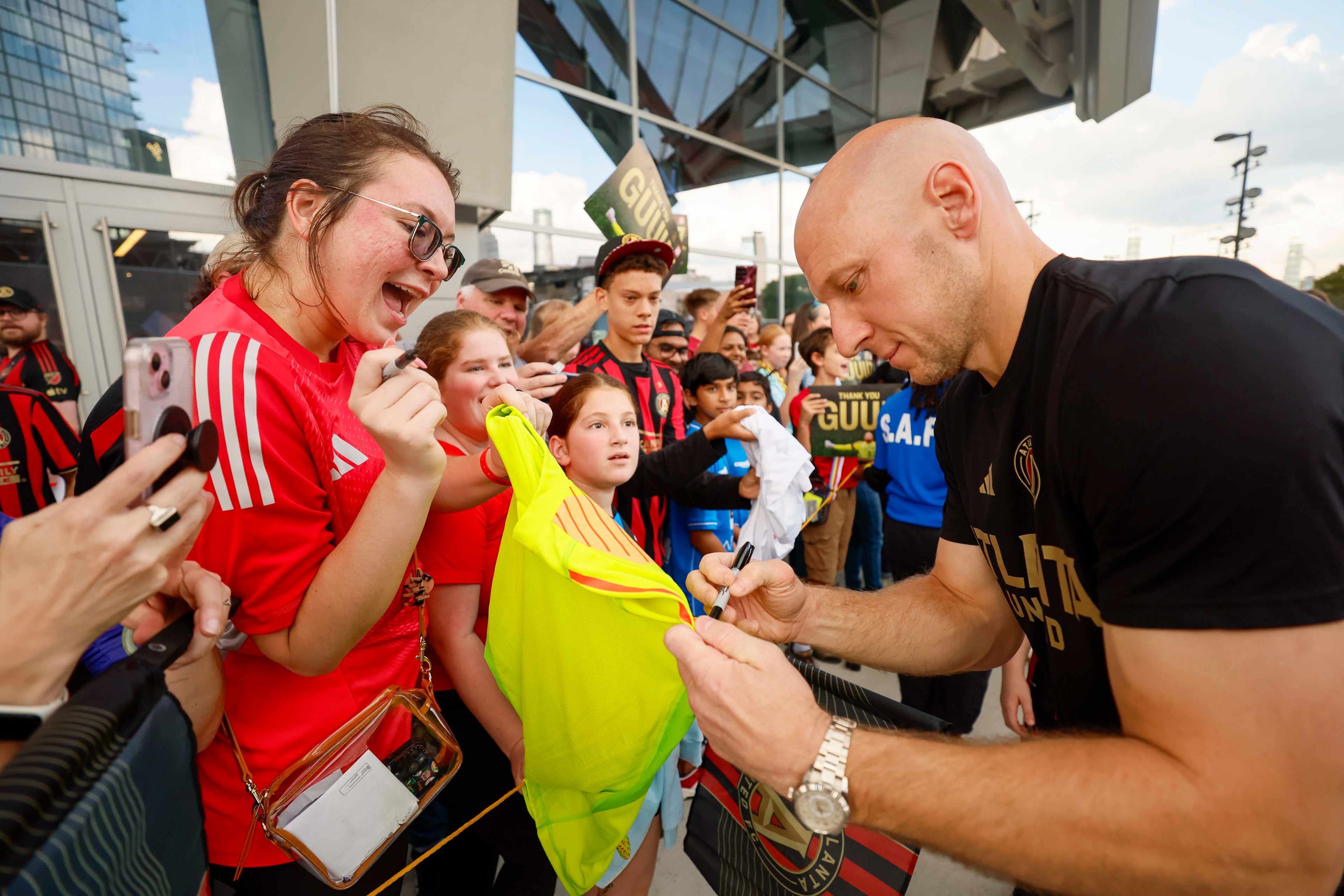An Atlanta United fan reacts as Atlanta United goalkeeper Brad Guzan signs her jersey prior to the game against D.C. United on Saturday, Oct. 18, 2025, at Mercedes-Benz Stadium in Atlanta. (Miguel Martinez/AJC)