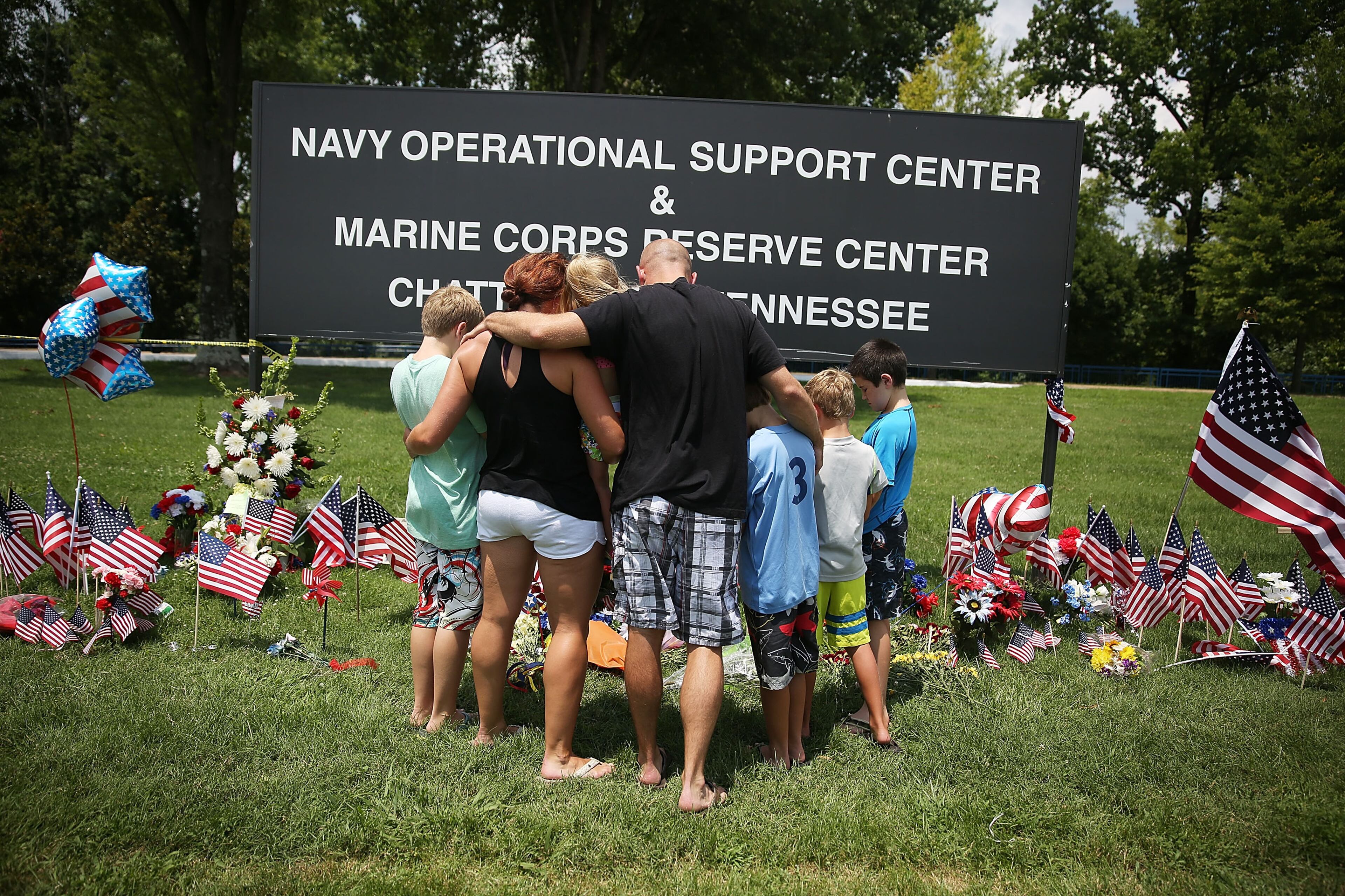 CHATTANOOGA, TN - JULY 18: Retired Marine Veteran, Brandon Hetrick, (C) prays with his family at a memorial setup at the entrance to the Navy Operational Support Center and Marine Corps Reserve Center where four United States Marines and a Navy sailor were killed on July 18, 2015 in Chattanooga, Tennessee. According to reports, Mohammod Youssuf Abdulazeez, 24, opened fire on the military recruiting station at the strip mall on July 16th and then drove more than seven miles away to an operational support center operated by the U.S. Navy and killed four United States Marines and a Navy sailor. The gunman was likely killed in a exchange of gunfire with the police. (Photo by Joe Raedle/Getty Images)