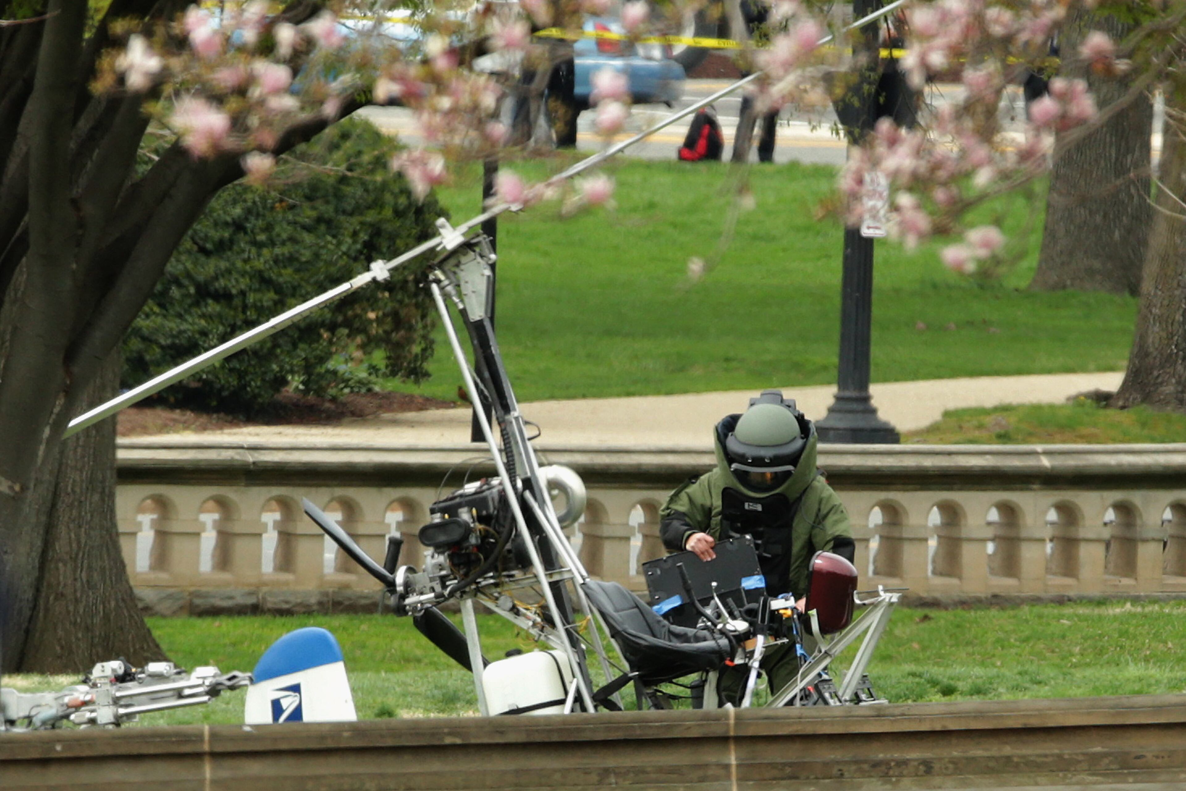 WASHINGTON, DC - APRIL 15: A member of the U.S. Capitol Police Bomb Squad works to check and secure a gyrocopter that landed on the West Front of the U.S. Capitol April 15, 2015 in Washington, DC. Doug Hughes, a 61-year-old postal worker from Ruskin, Florida, landed the lightweight helicopter on the Capitol lawn to protest against government corruption and to promote campaign finance reform. (Photo by Chip Somodevilla/Getty Images)
