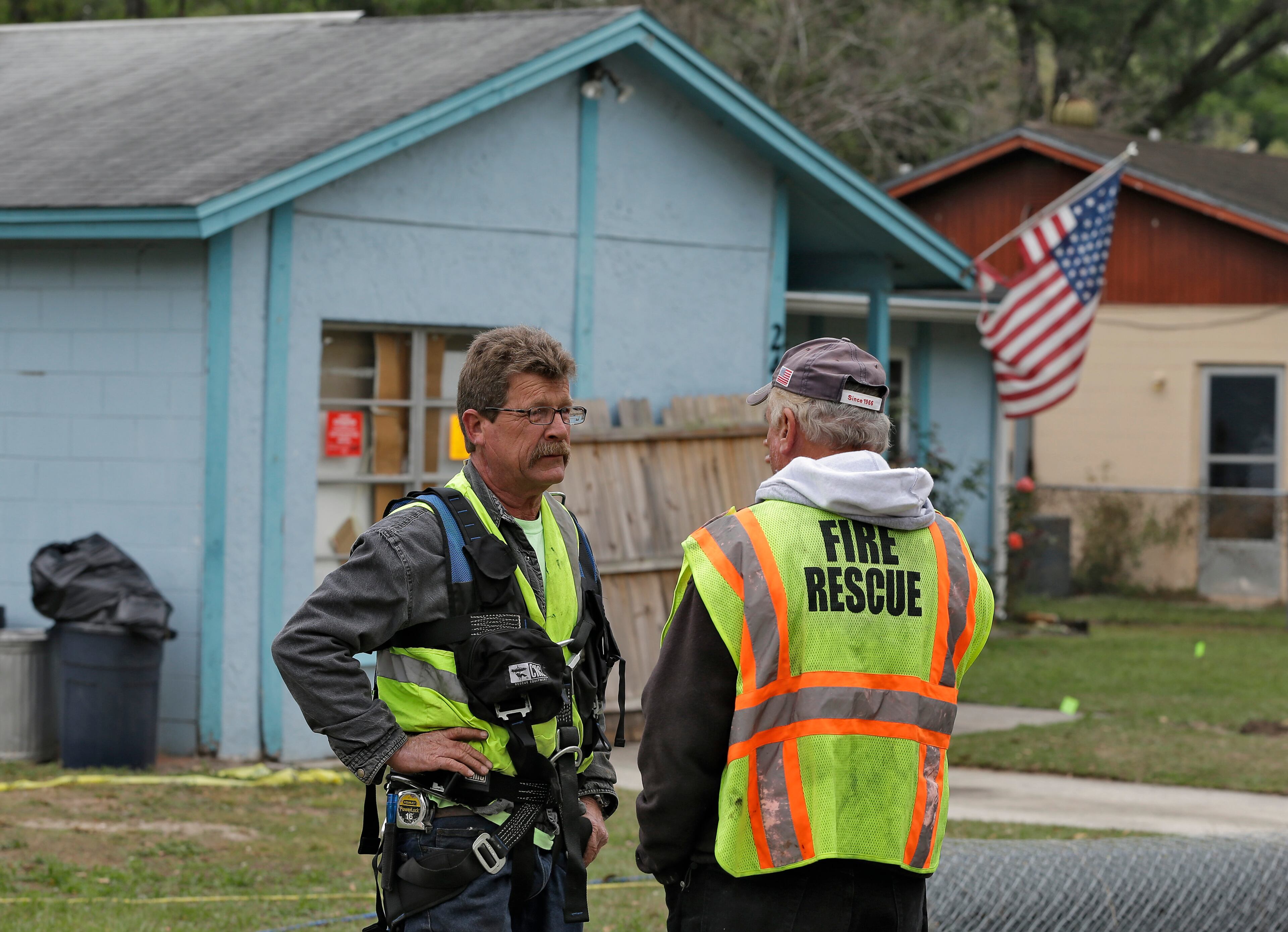 Engineers talk in front of the home.