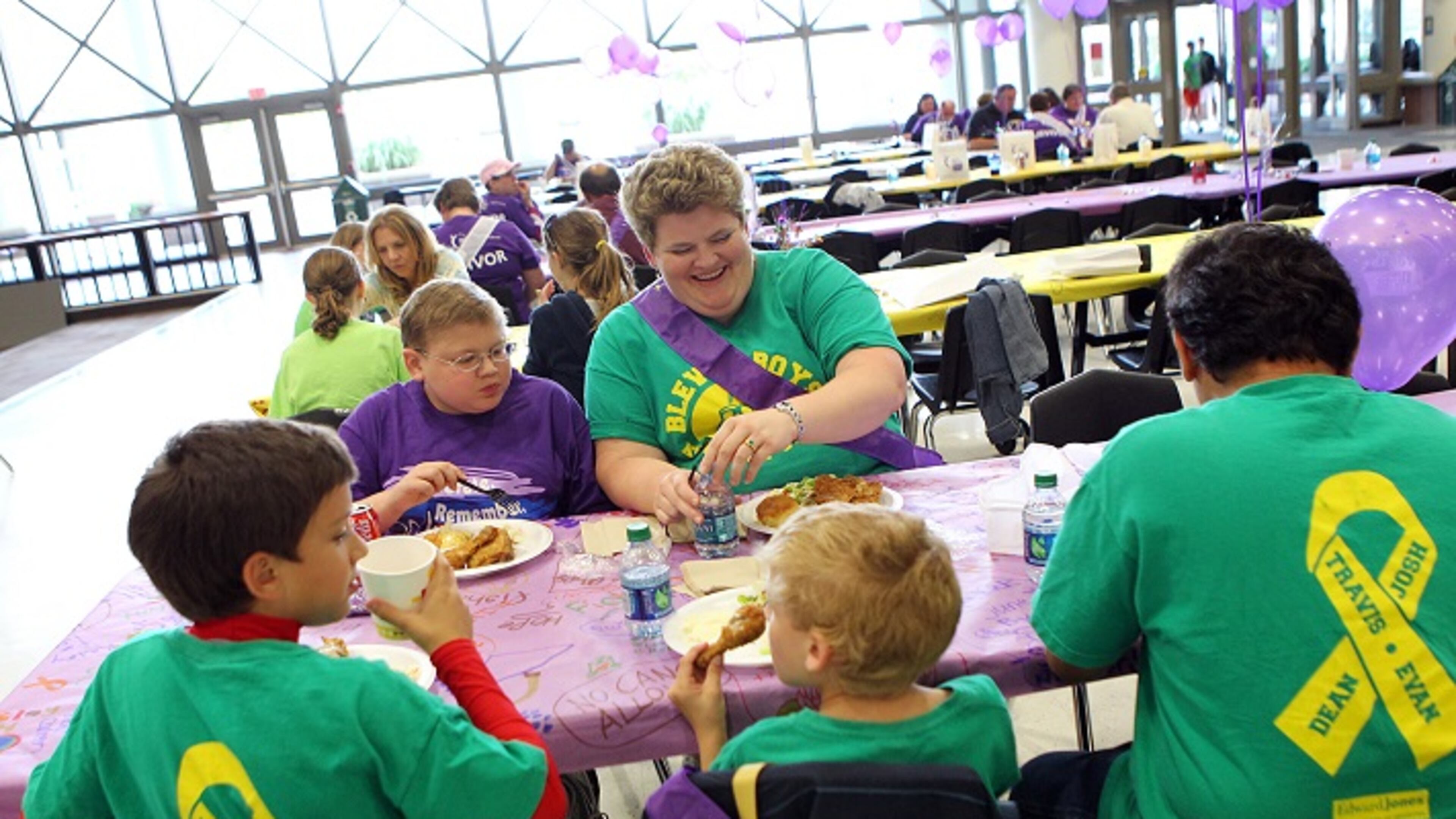 Evan Pina-White (facing on left), 13, from Eureka and his mother Mary White (facing on right) sit with the rest of their family during the Rockwood School District's American Cancer Society Relay for Life survivor's dinner on Friday, June 1, 2012, in Fenton. Pictured from left to right in the foreground are White's other sons Bennett Pina-White, 8, Gabe Pina-White, 6, and her husband Luis Pina. (Johnny Andrews/St. Louis Post-Dispatch/TNS)