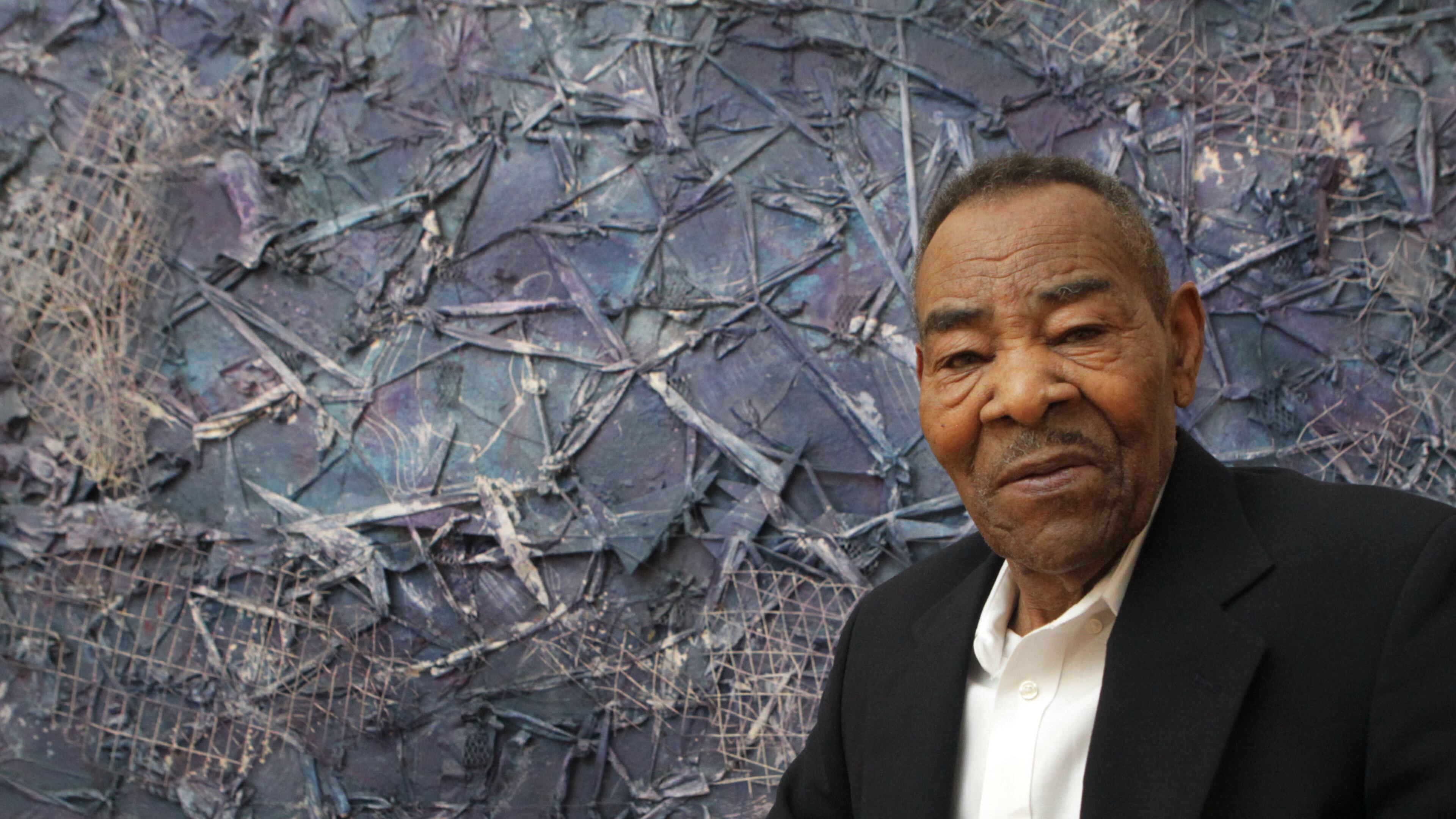Artist Thornton Dial in front of his assemblage, "Crossing Waters," on display at the High Museum of Art in November 2012. (AJC File)