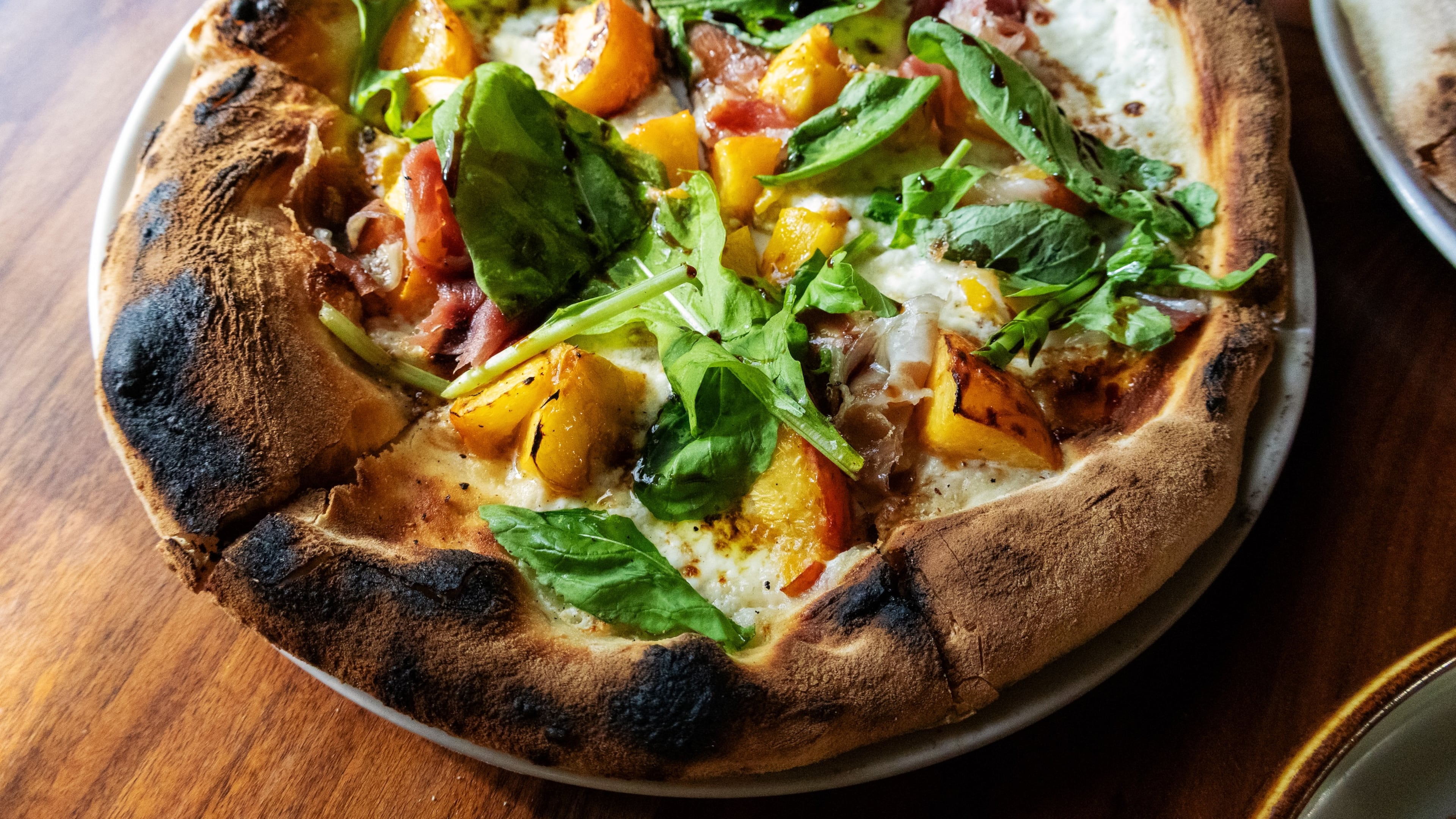 Sweet, wood-fired peaches meet rich smoked mascarpone, ribbons of prosciutto and fresh arugula at Ecco.
(Courtesy of Ecco)