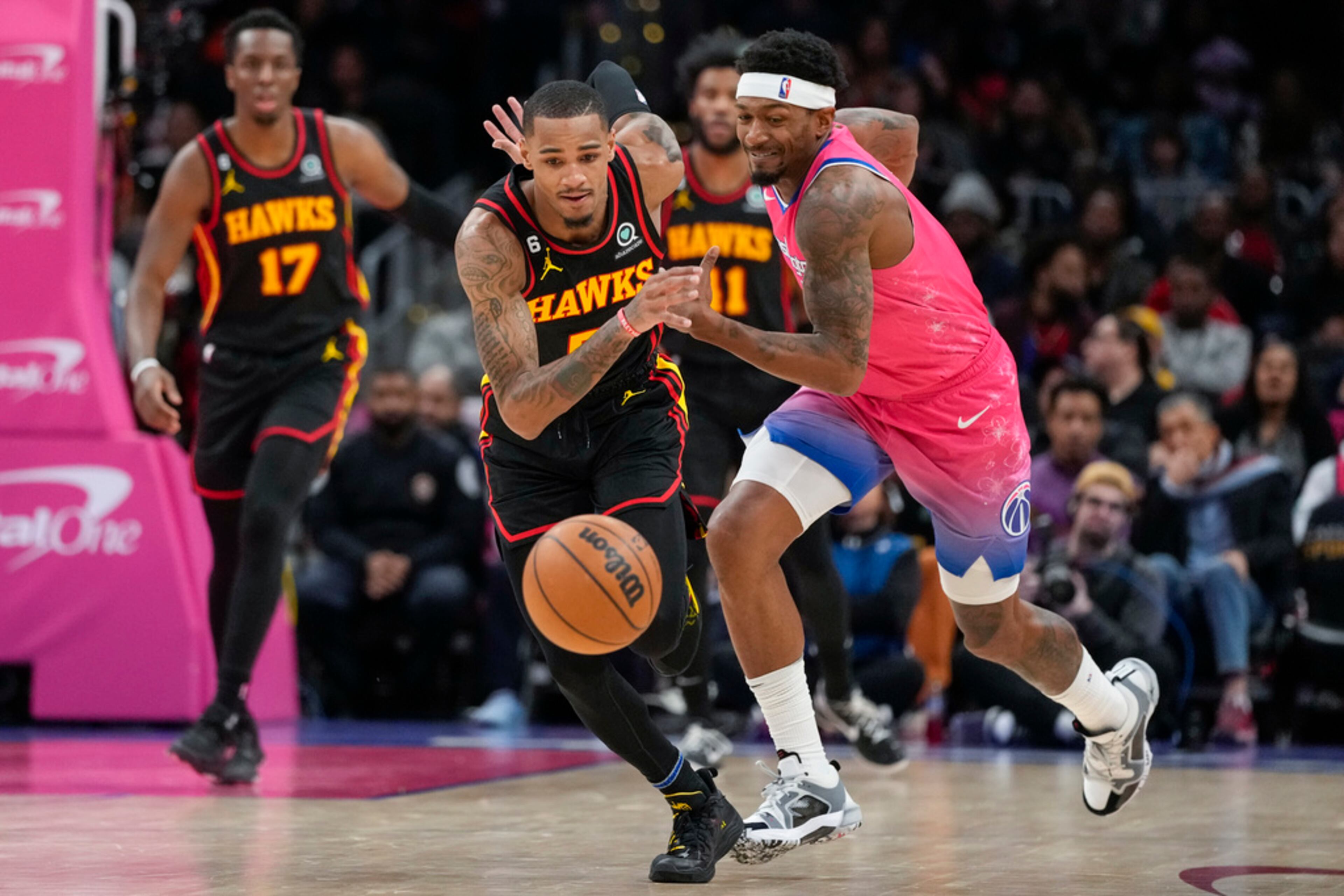 Atlanta Hawks guard Dejounte Murray (5) chases the loose ball with Washington Wizards guard Bradley Beal (3) during the second half of an NBA basketball game Wednesday, March 8, 2023, in Washington. The Hawks won 122-120. (AP Photo/Alex Brandon)