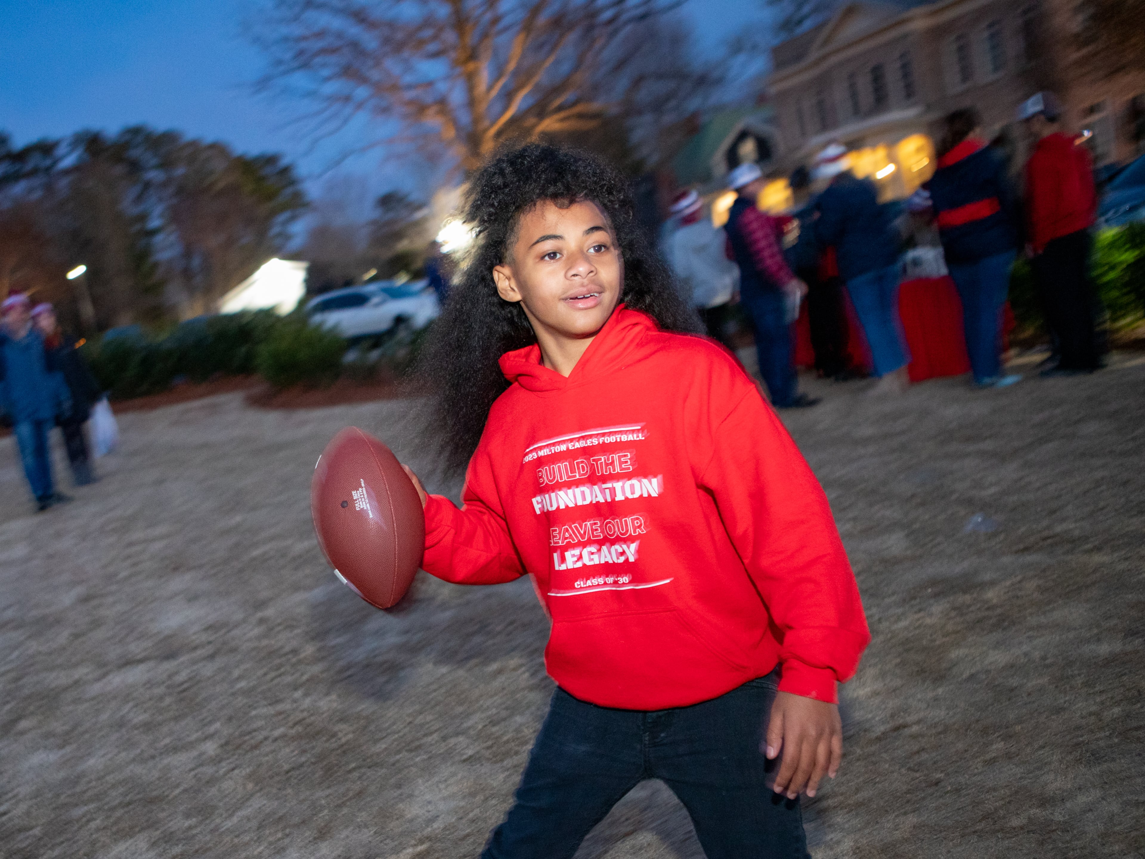 During the Milton High School 7A State Football Champions celebration De Amari Rumph, 12, tosses with friends on Milton Green on Wednesday, Dec 20, 2023. (Jenni Girtman for The Atlanta Journal-Constitution)