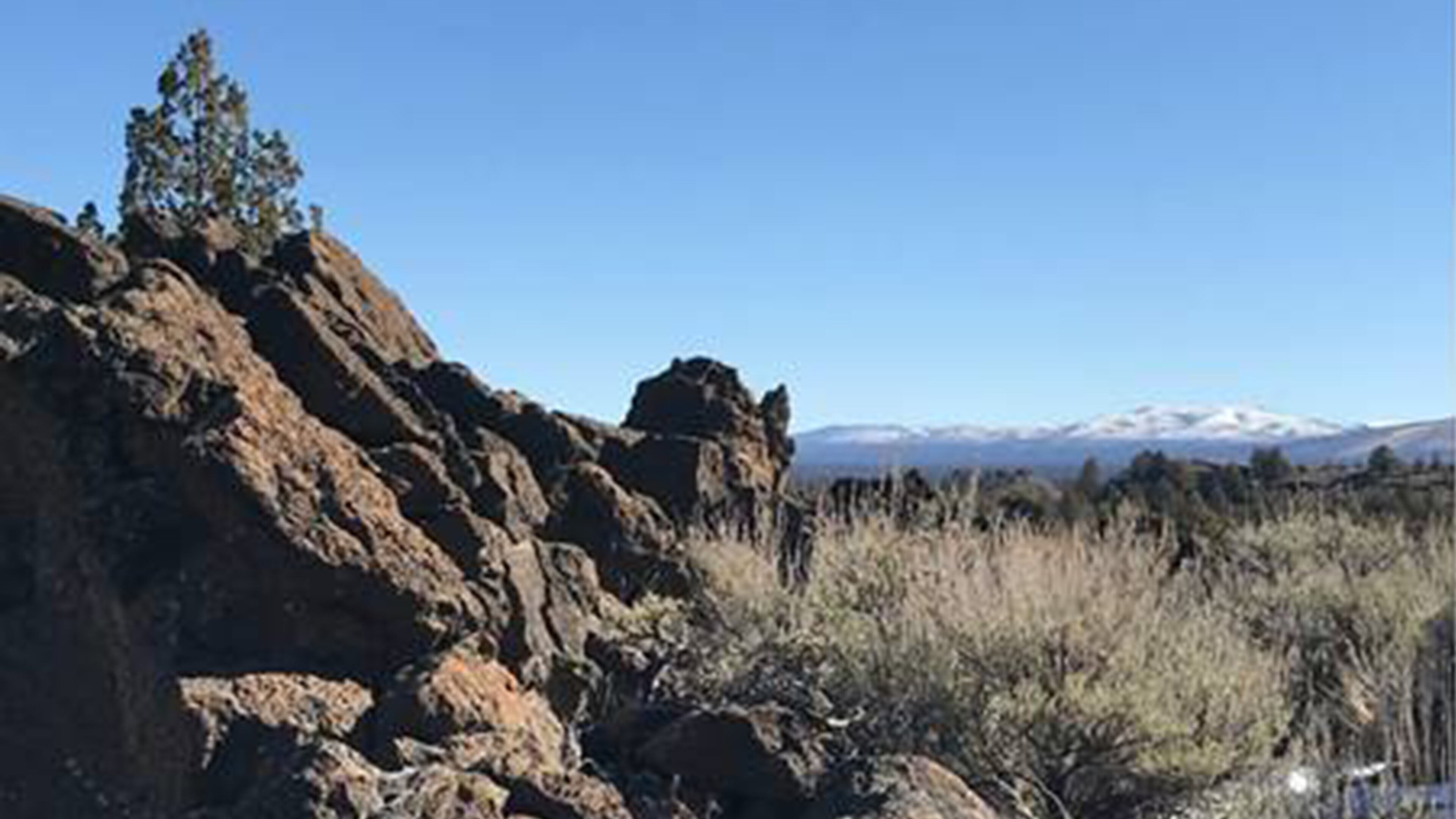 Snow-covered hills can be seen in the distance from Flatiron Rock in the Badlands. (Mark Morical/The Bulletin/TNS)