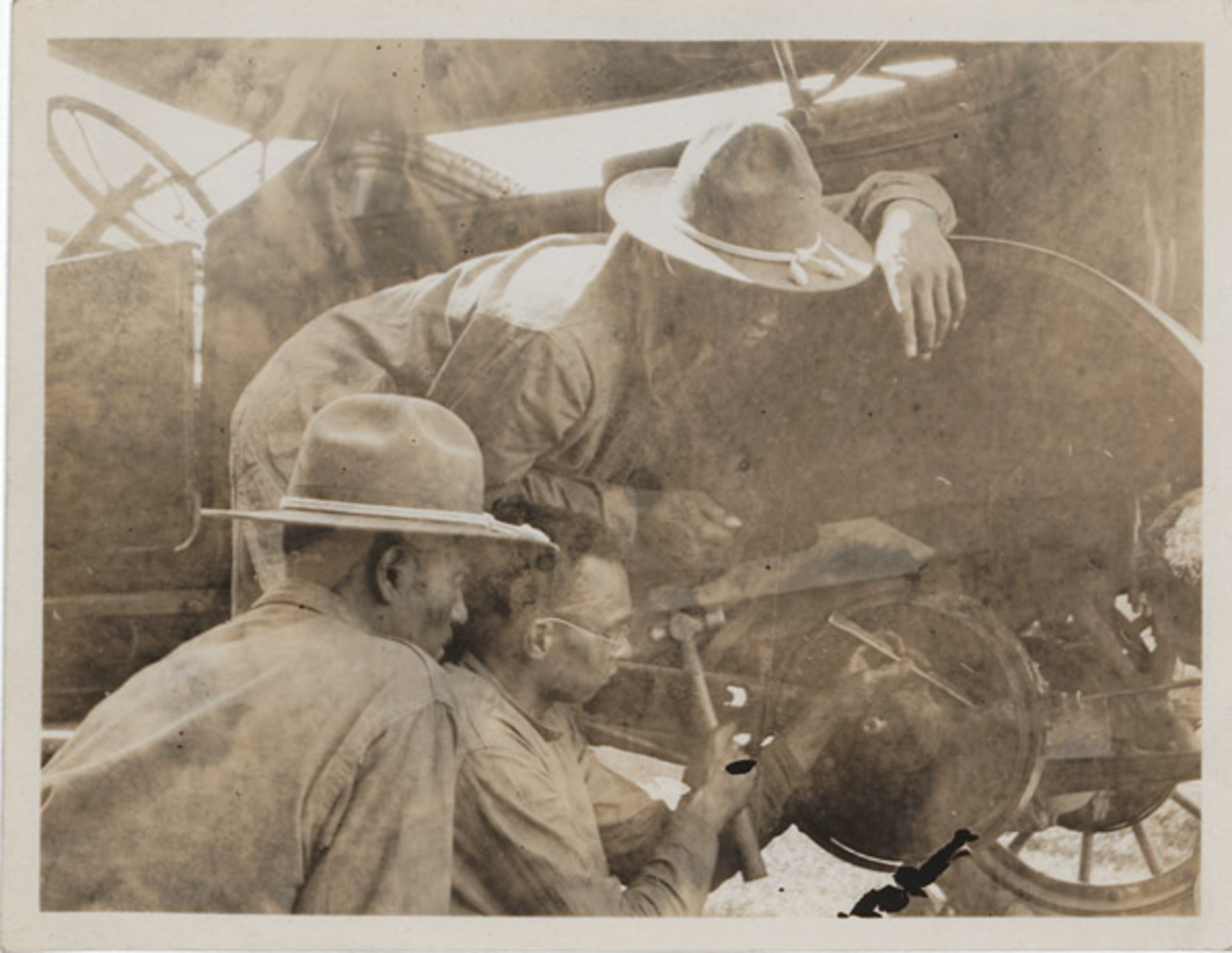 Three soldiers handle a roadside repair problem on an automobile, then still a relatively new mode of transportation.