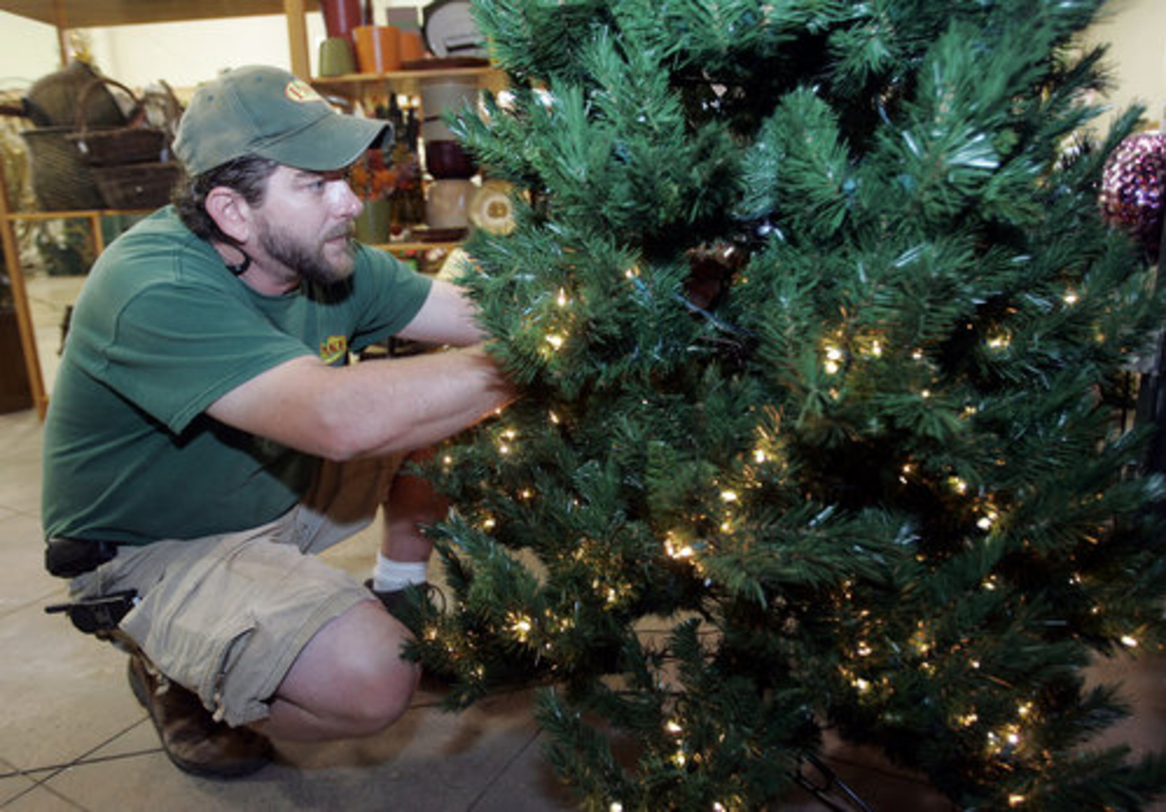 What's "in" this year: big snowmen and lots of lights. Phil Talton works on Christmas tree lights at Pikes.