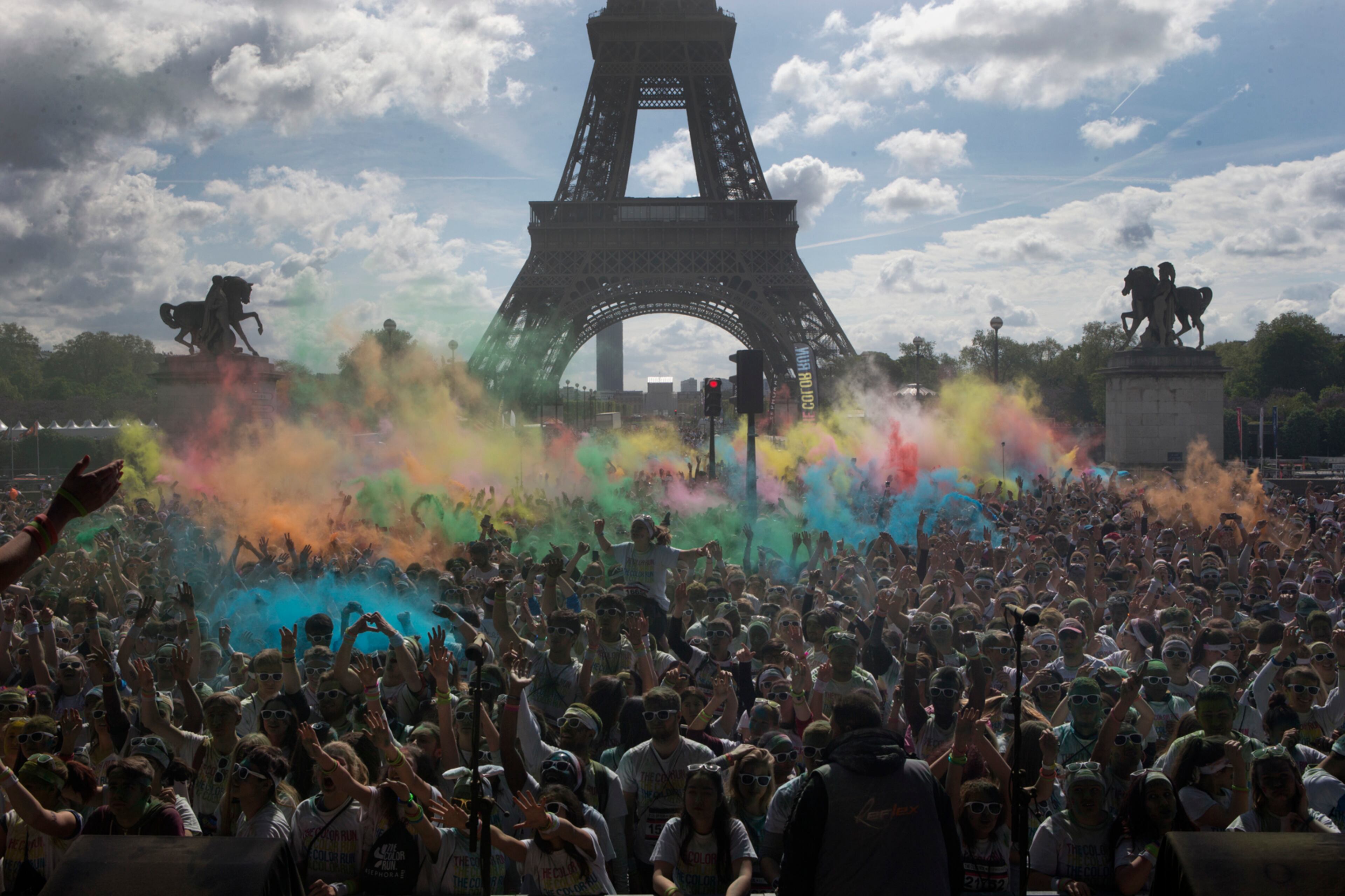 People take part in the Color Run near the Eiffel Tower, in Paris, Sunday, April 16, 2017. The Color Run is a 5 kilometer (3.1 mile) running event where participants are covered in bright colored powder at each check station and is less about speed and more about enjoying a day with friends and family. (AP Photo/Francois Mori)