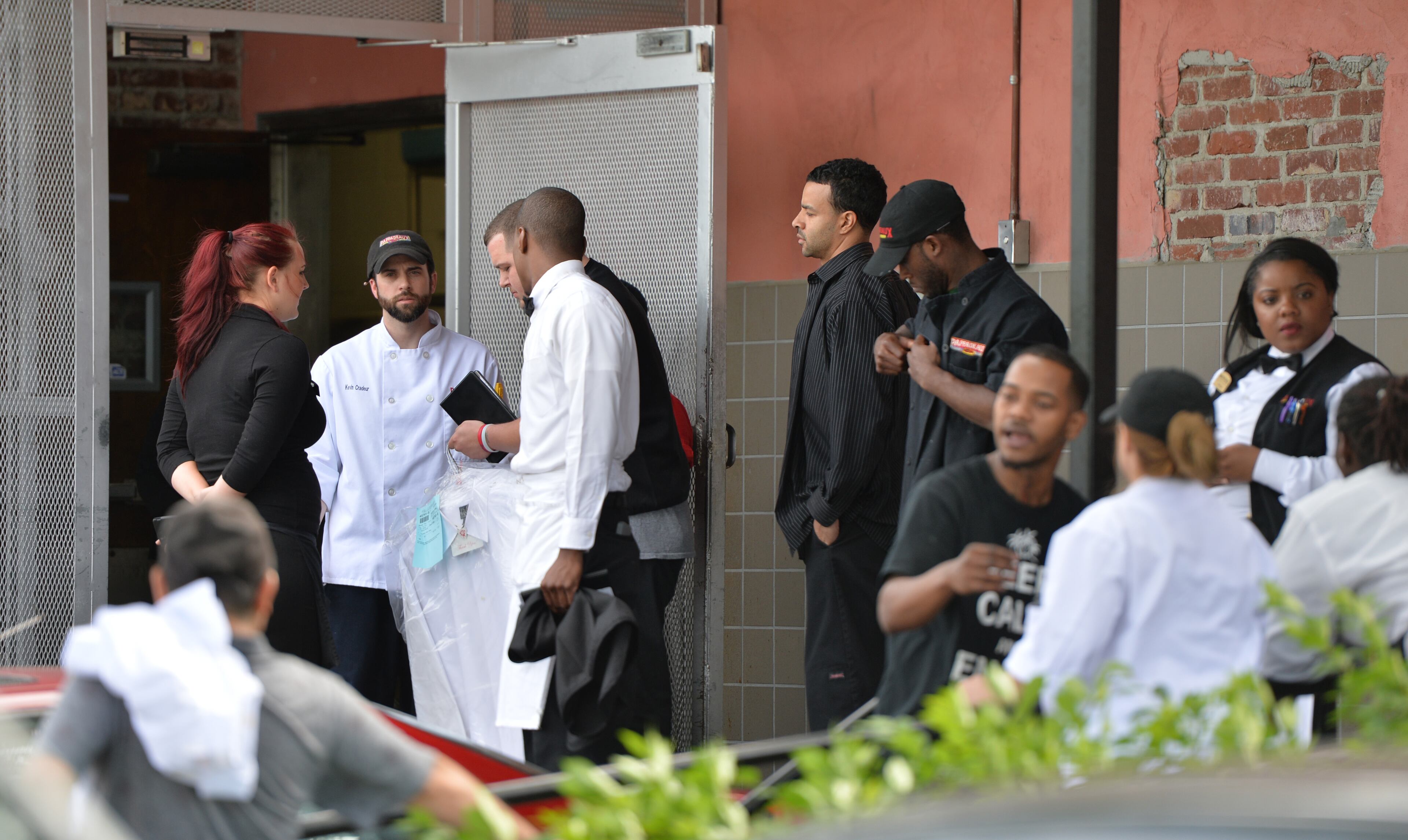 Restaurant employees gather in the parking lot of Pappadeaux Seafood Kitchen, where at least one victim was shot multiple times, near the intersection of I-85 and Jimmy Carter Boulevard in Norcross on Friday afternoon, May 2, 2014. HYOSUB SHIN / HSHIN@AJC.COM