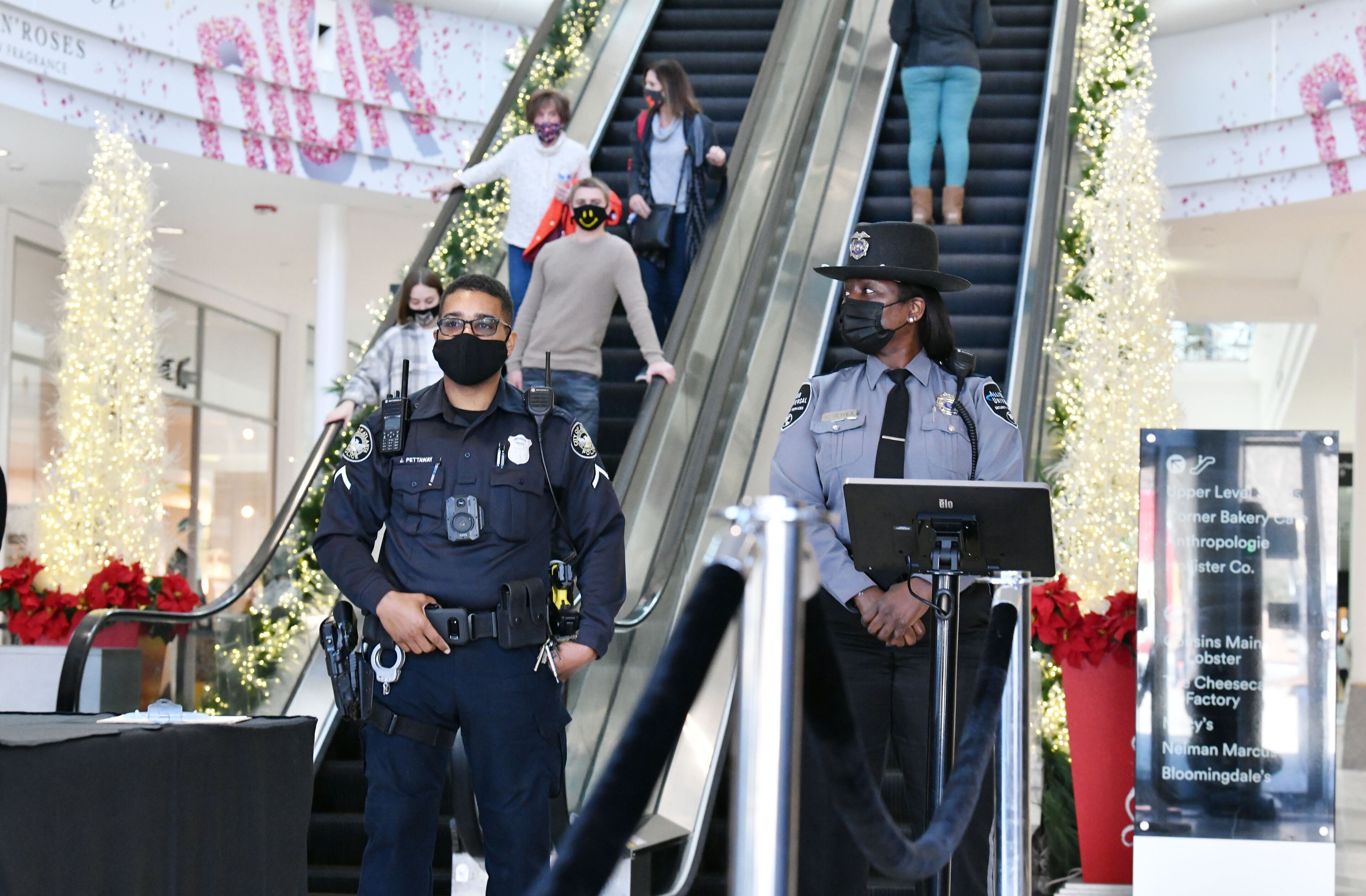 Atlanta police officer and private security officer monitor shoppers at Lenox Square on Tuesday, Dec. 29, 2020. Lenox Square, in the heart of Buckhead, was the site of numerous shooting incidents that year. The Atlanta Police Department has a mini-precinct inside the mall, which has increased security in recent months. (Hyosub Shin / Hyosub.Shin@ajc.com)