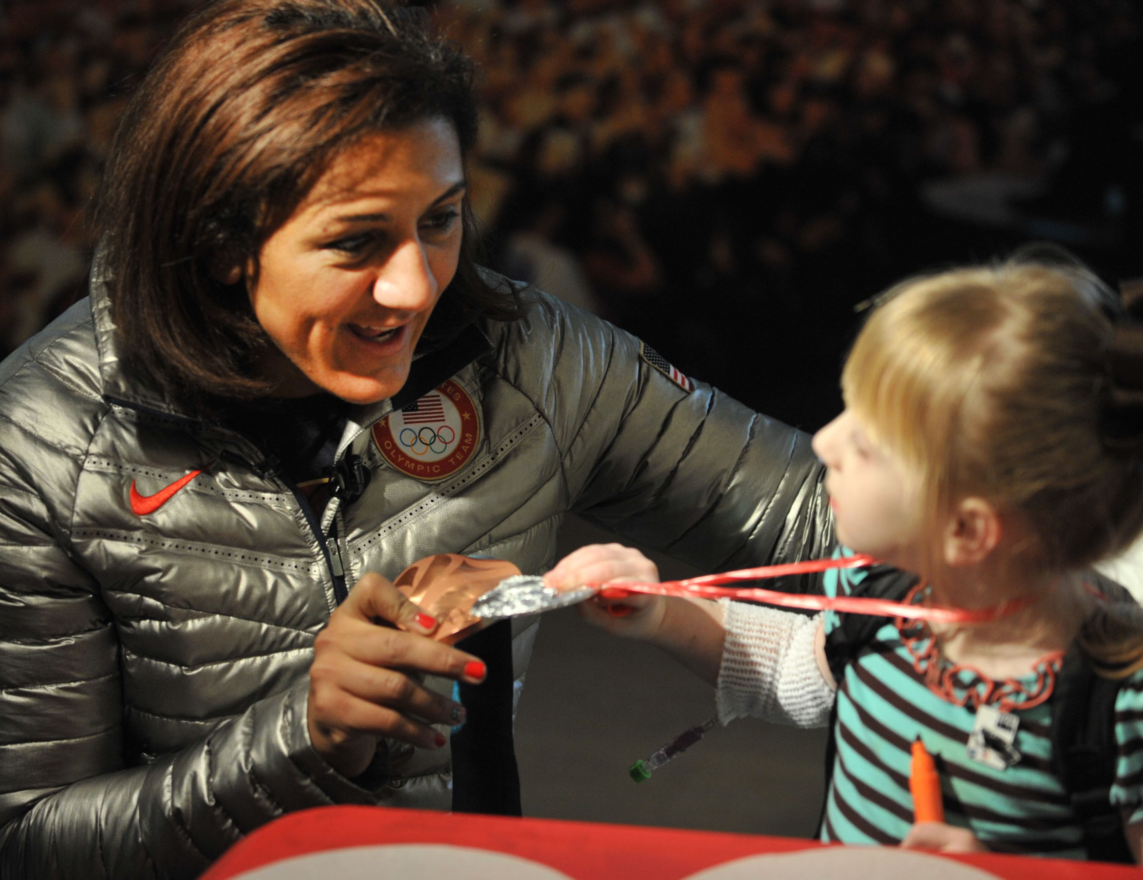 Bobsledder and Douglasville-native Elana Meyers compares her bronze medal from the 2010 Winter Olympics games to the silver of Hanna Evans, 4, of Lawrenceville, touch her silver medal during a visit to The Zone at Children's Healthcare of Atlanta at Scottish Rite. KENT D. JOHNSON / KDJOHNSON@AJC.COM