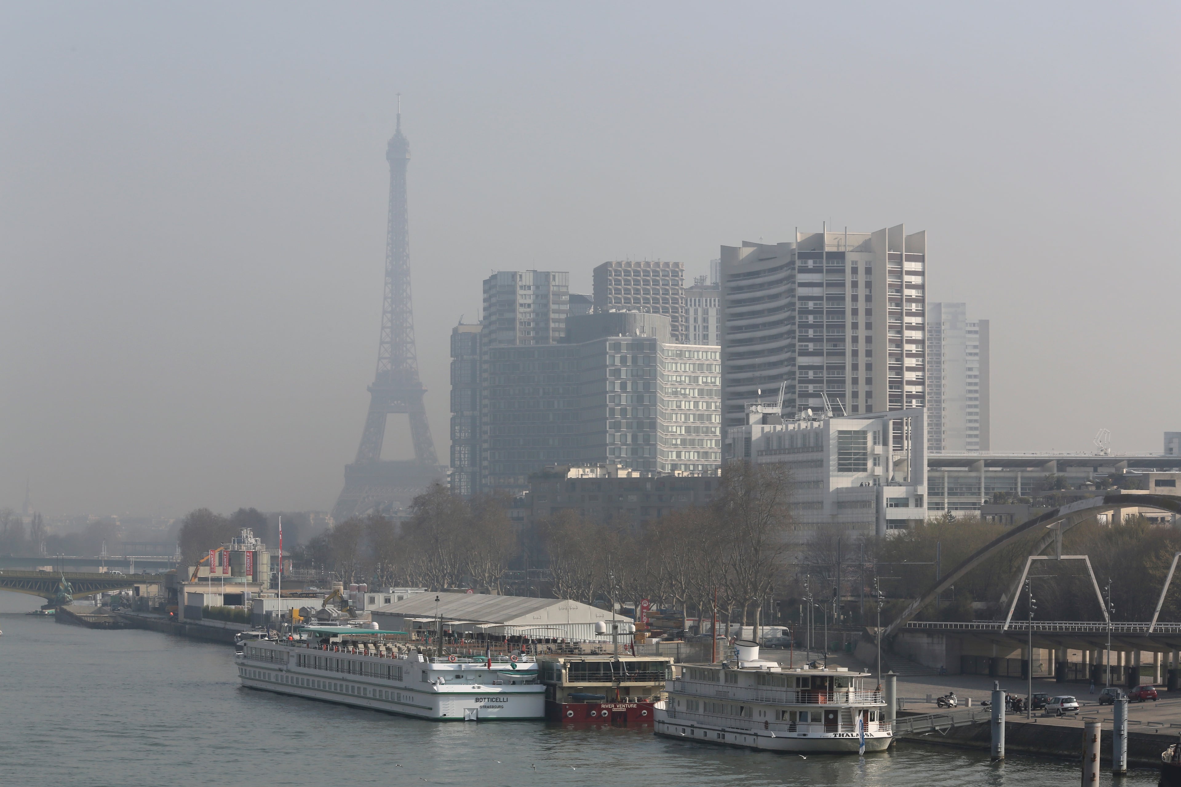 The Eiffel Tower and the Beaugrenelle district, right, are seen through the smog in Paris, Thursday March 13, 2014, as pollution over the French capital is at high levels.